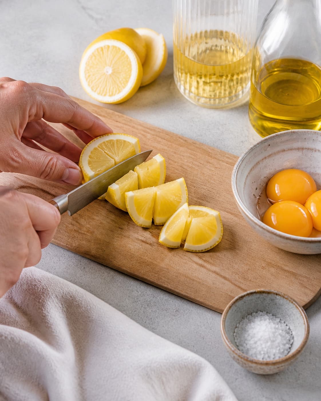 Ingredients for hjemmelavet mayonnaise being cut into even pieces under tilberedningen af hjemmelavet mayonnaise