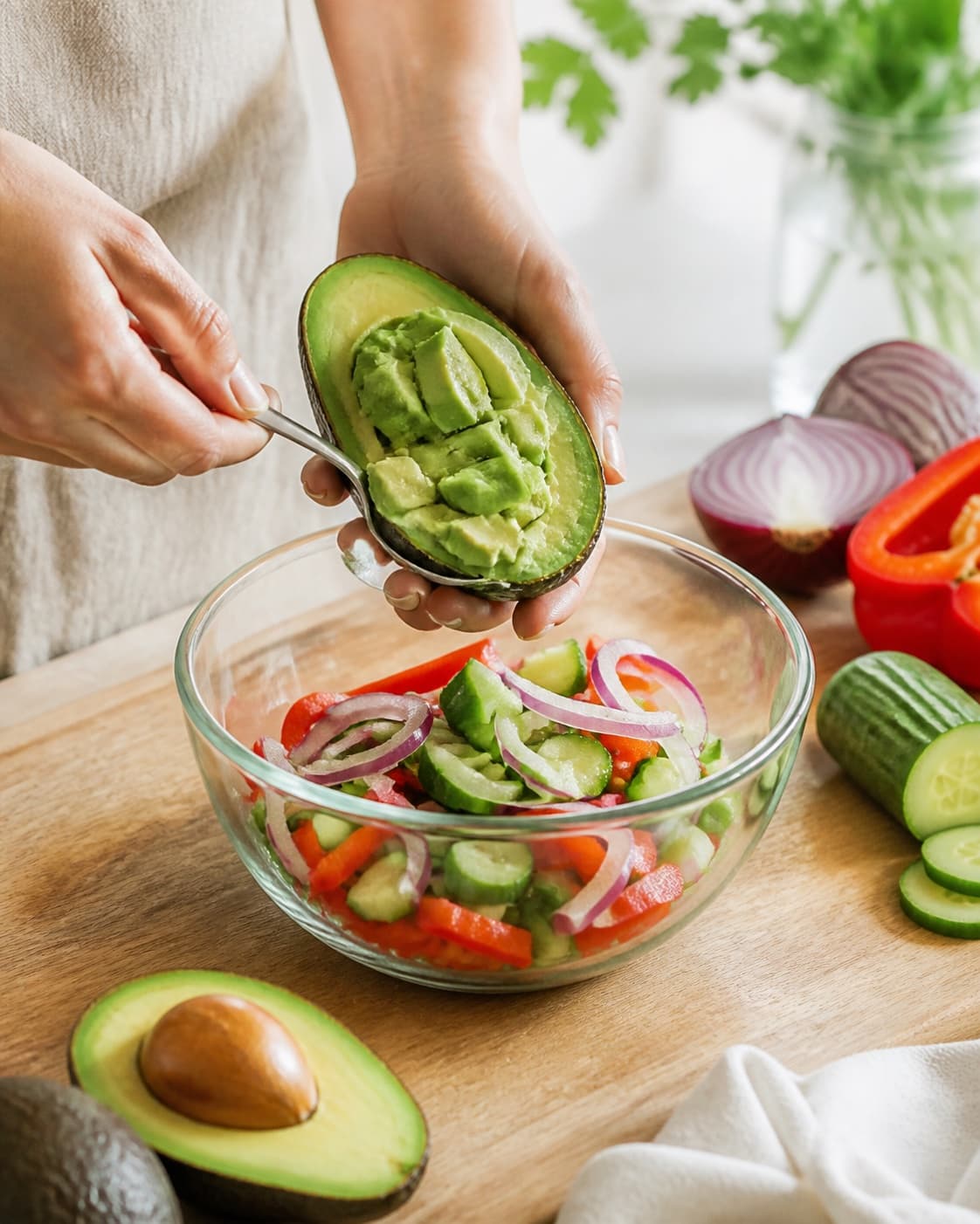 Clean prepared ingredients for avocadosalat med agurk, rødløg og rød peber with rødløg, agurk, modne avocadoer, rød peberfrugt under tilberedningen af avocadosalat med agurk, rødløg og rød peber