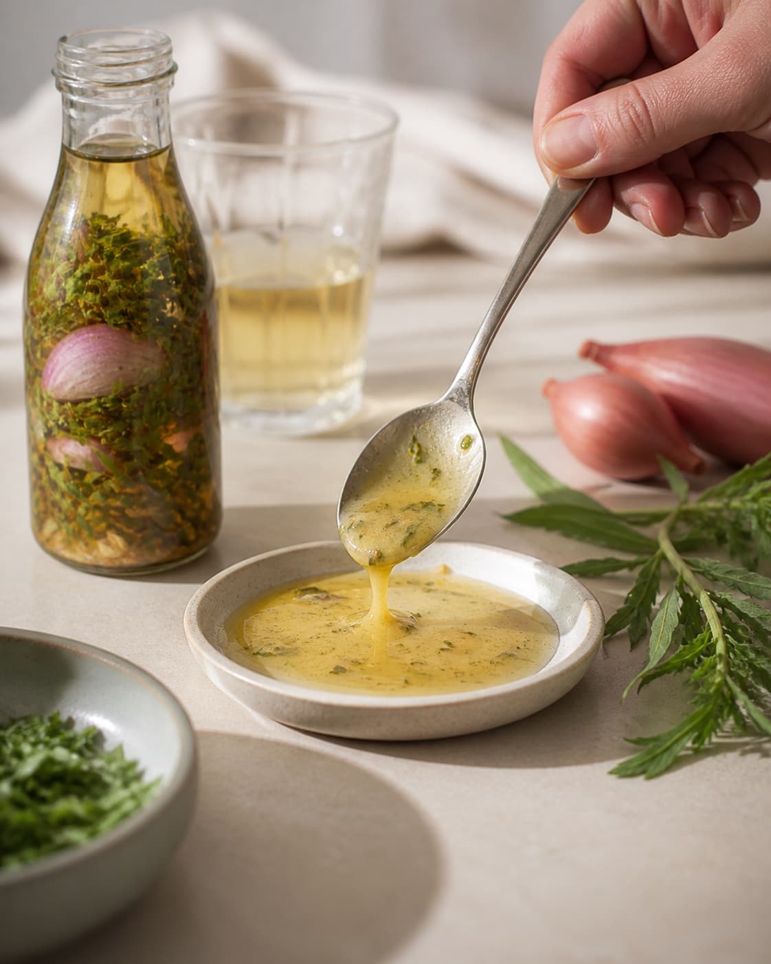 A chilled consistency test for hjemmelavet bearnaise essens on a small plate under tilberedningen af hjemmelavet bearnaise essens