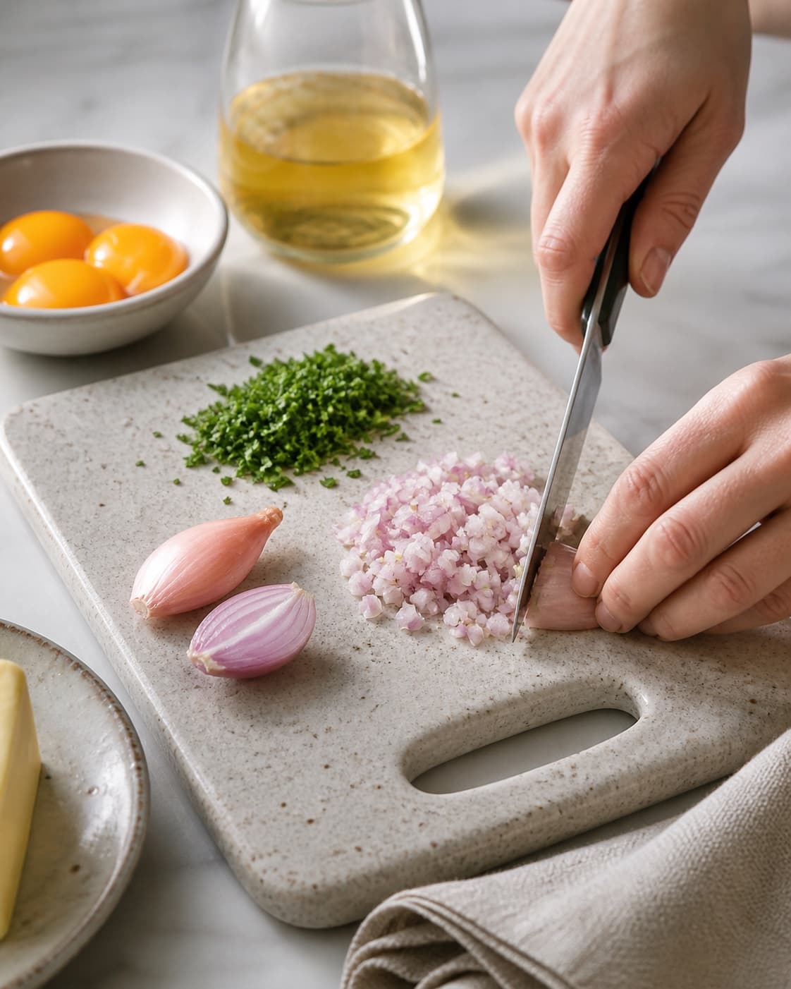 Ingredients for bearnaise sauce being cut into even pieces under tilberedningen af bearnaise sauce