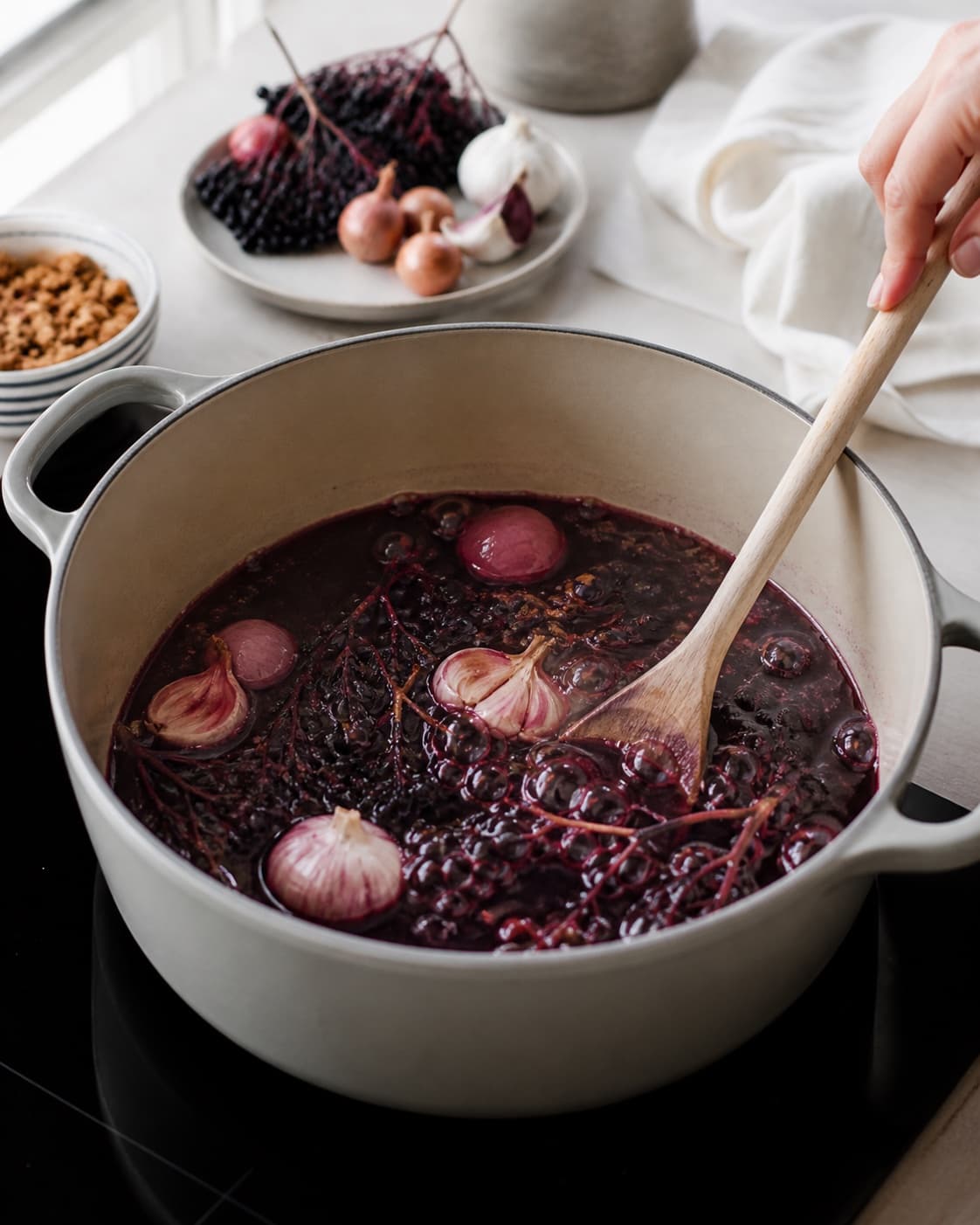 Aromatic base for hyldebærsuppe med flødeskum og knas gently cooking in a pot under tilberedningen af hyldebærsuppe med flødeskum og knas