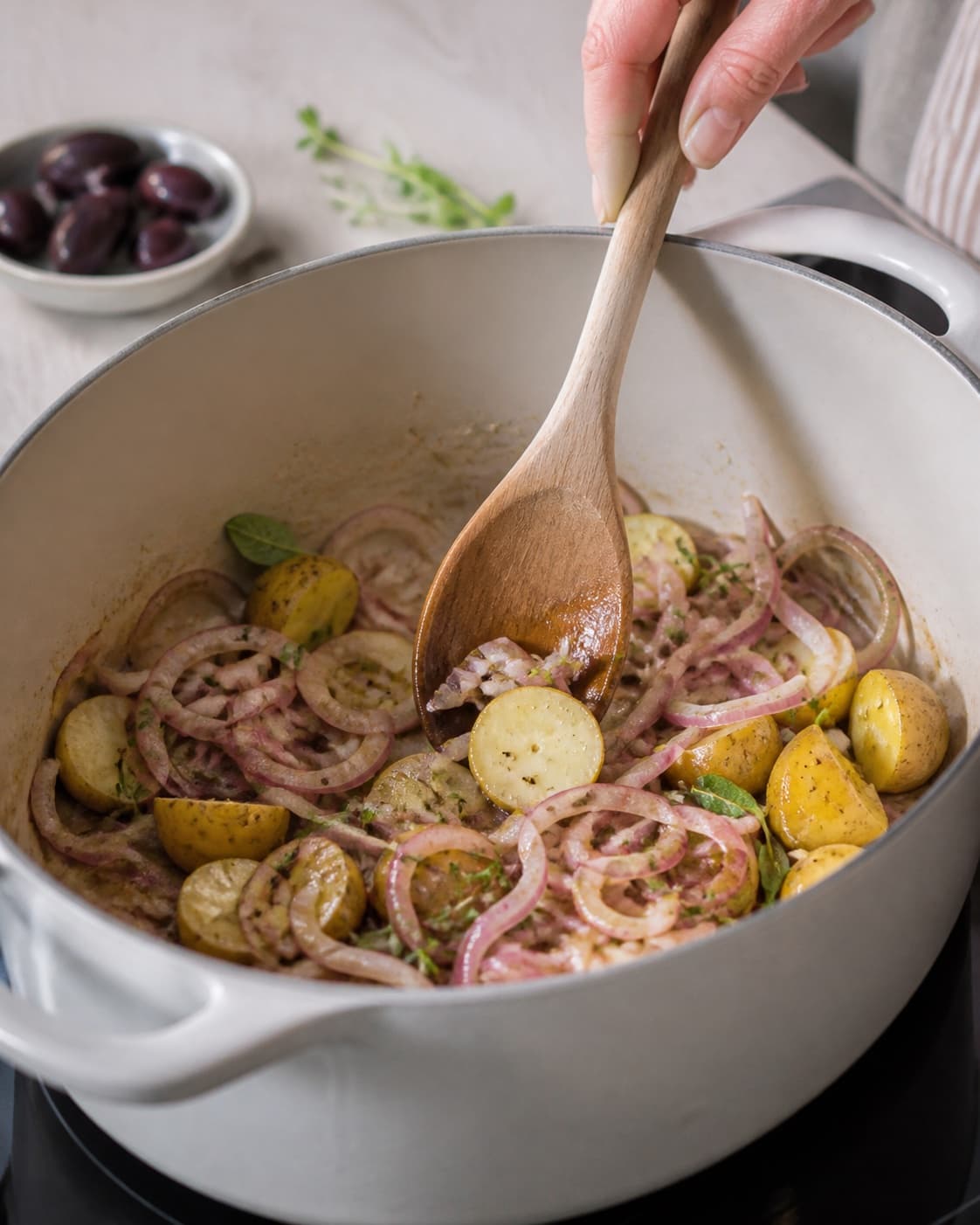Aromatic base for salade nicoise gently cooking in a pot under tilberedningen af salade nicoise