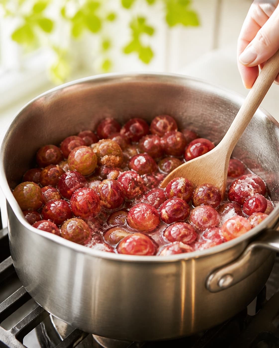 Ingredients for stikkelsbærmarmelade gently releasing juice in a pot under tilberedningen af stikkelsbærmarmelade