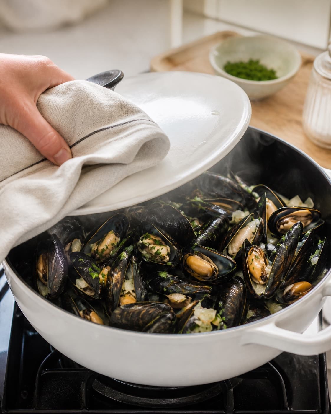 dampede muslinger: moules marinières gently simmering with visible ingredients under tilberedningen af dampede muslinger: moules marinières