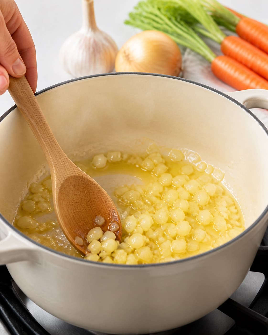 Aromatic base for gulerodspuré gently cooking in a pot under tilberedningen af gulerodspuré