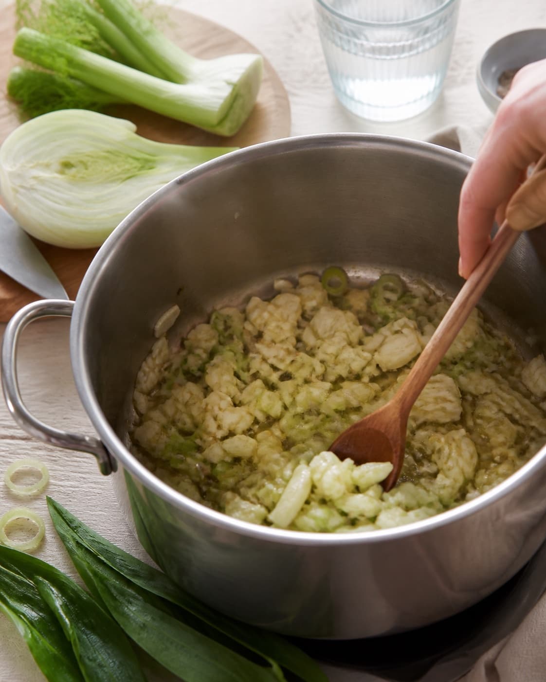 Aromatic base for bygotto med fennikel og ramsløg gently cooking in a pot under tilberedningen af bygotto med fennikel og ramsløg