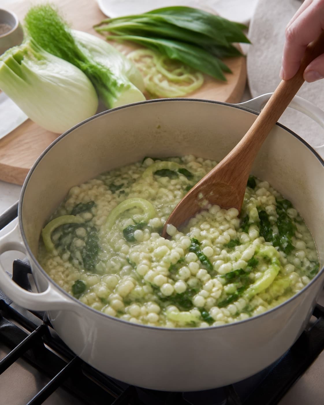 bygotto med fennikel og ramsløg gently simmering with visible ingredients under tilberedningen af bygotto med fennikel og ramsløg