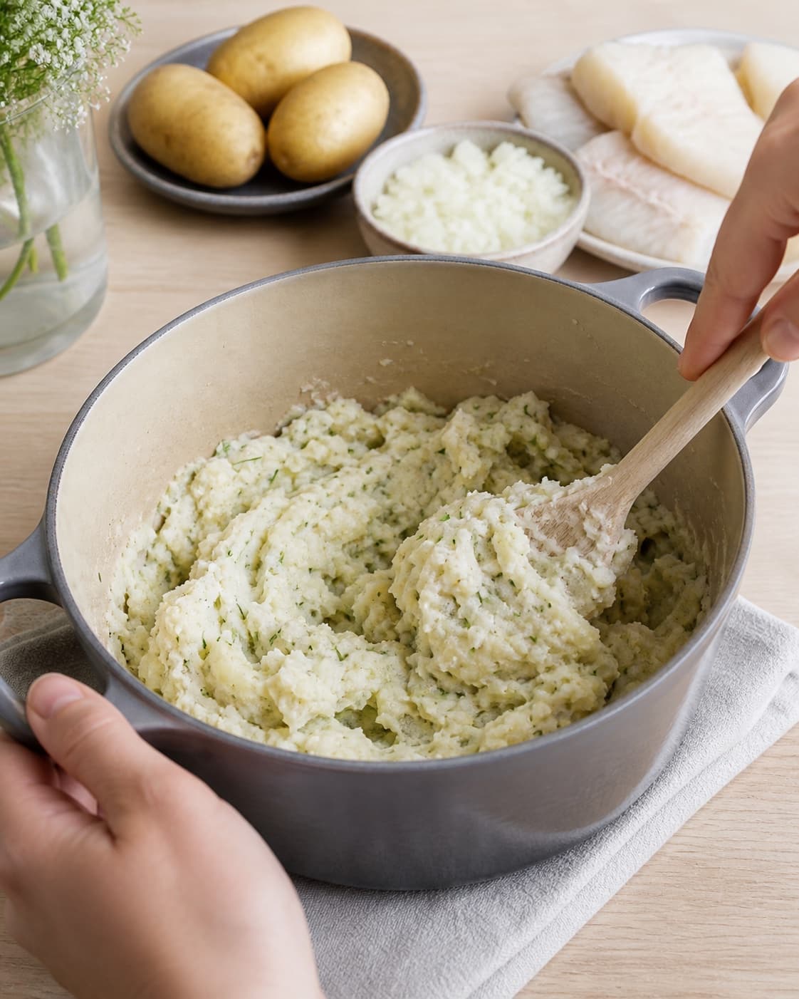 The texture of brandade med torsk being adjusted in the pot under tilberedningen af brandade med torsk