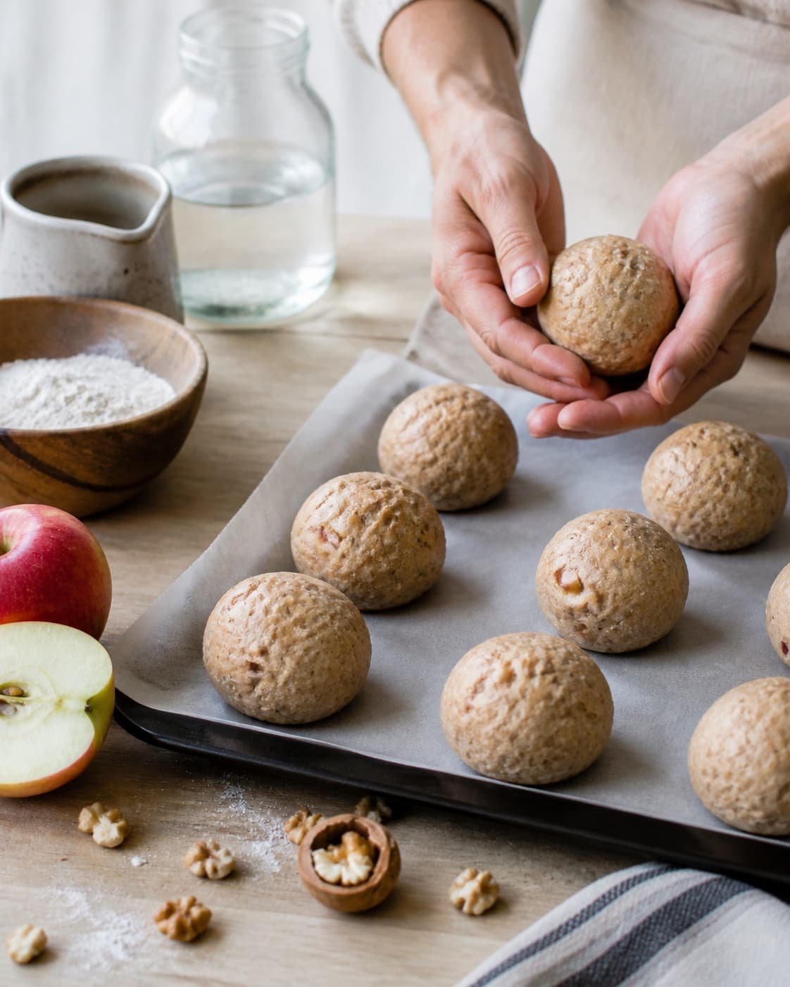 Even pieces of æbleboller med nødder being shaped before baking under tilberedningen af æbleboller med nødder