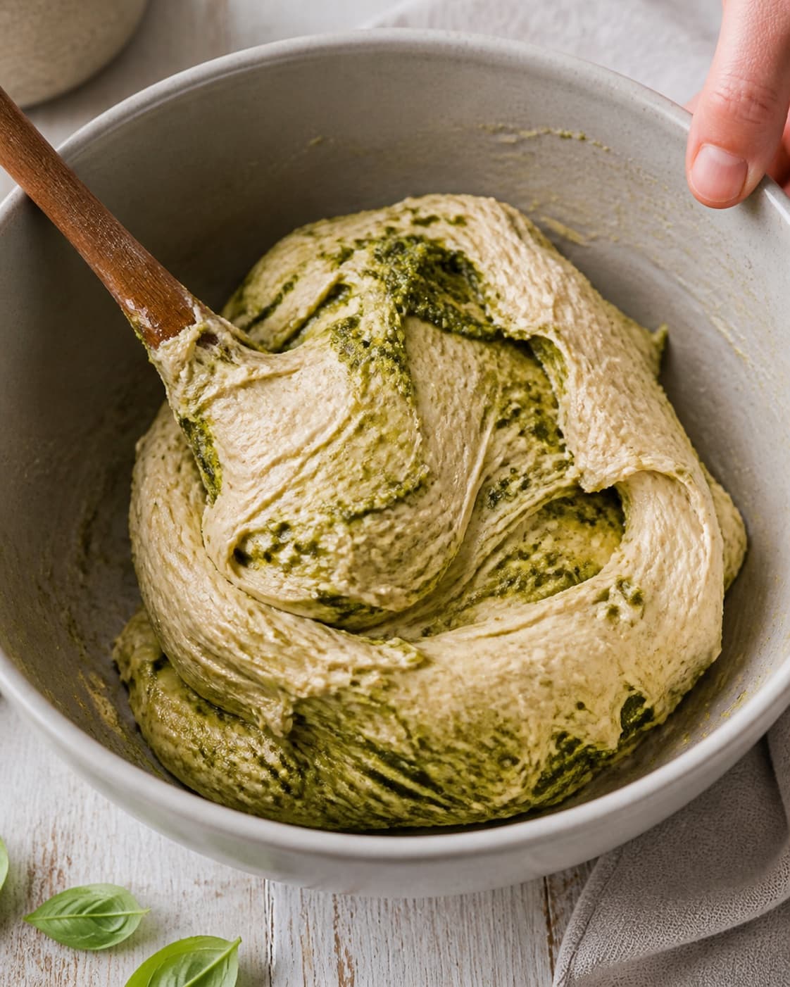 Close view of the moist dough for pestosnurrer being mixed in a bowl with basilikumpesto, hvedemel, lunkent vand, gær under tilberedningen af pestosnurrer