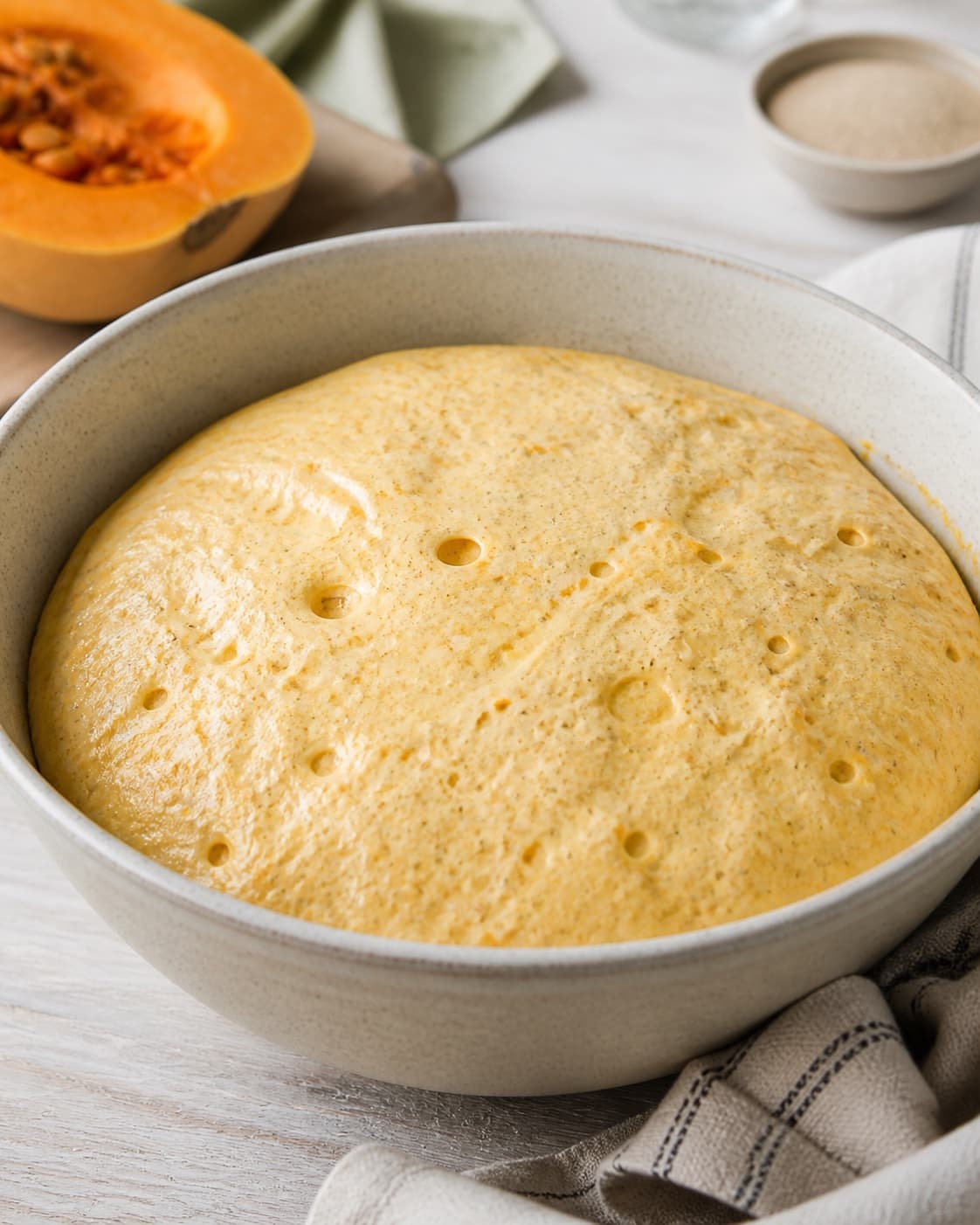 Proofed airy dough for græskarboller with visible fermentation bubbles under tilberedningen af græskarboller