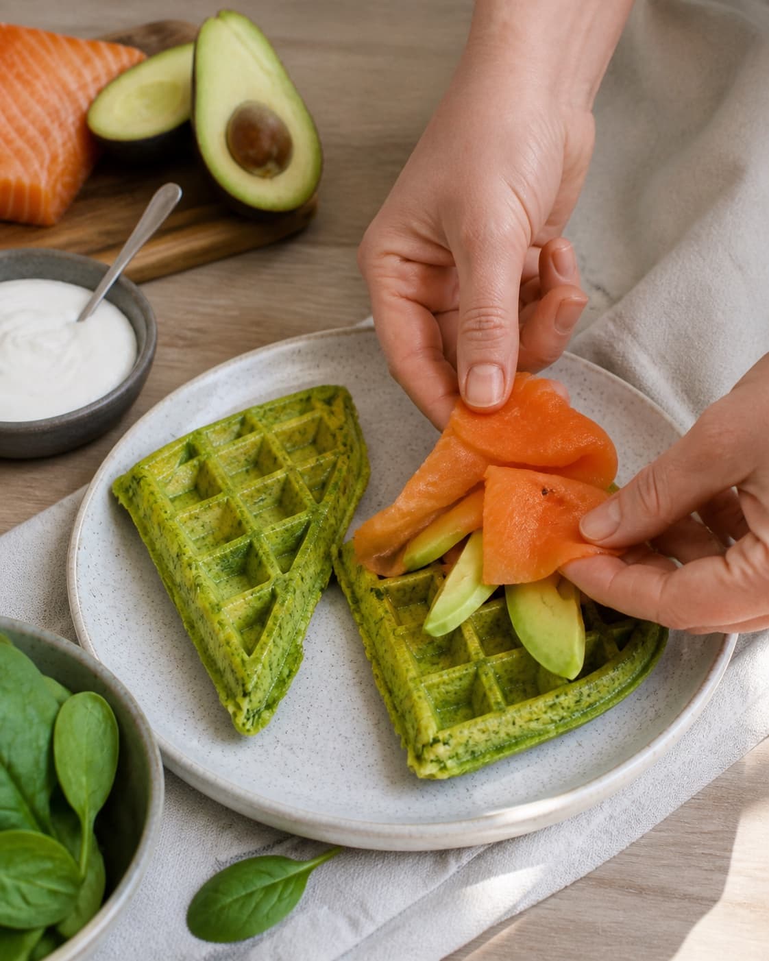 Equal portions of spinatvafler med røget laks og avocado being formed under tilberedningen af spinatvafler med røget laks og avocado