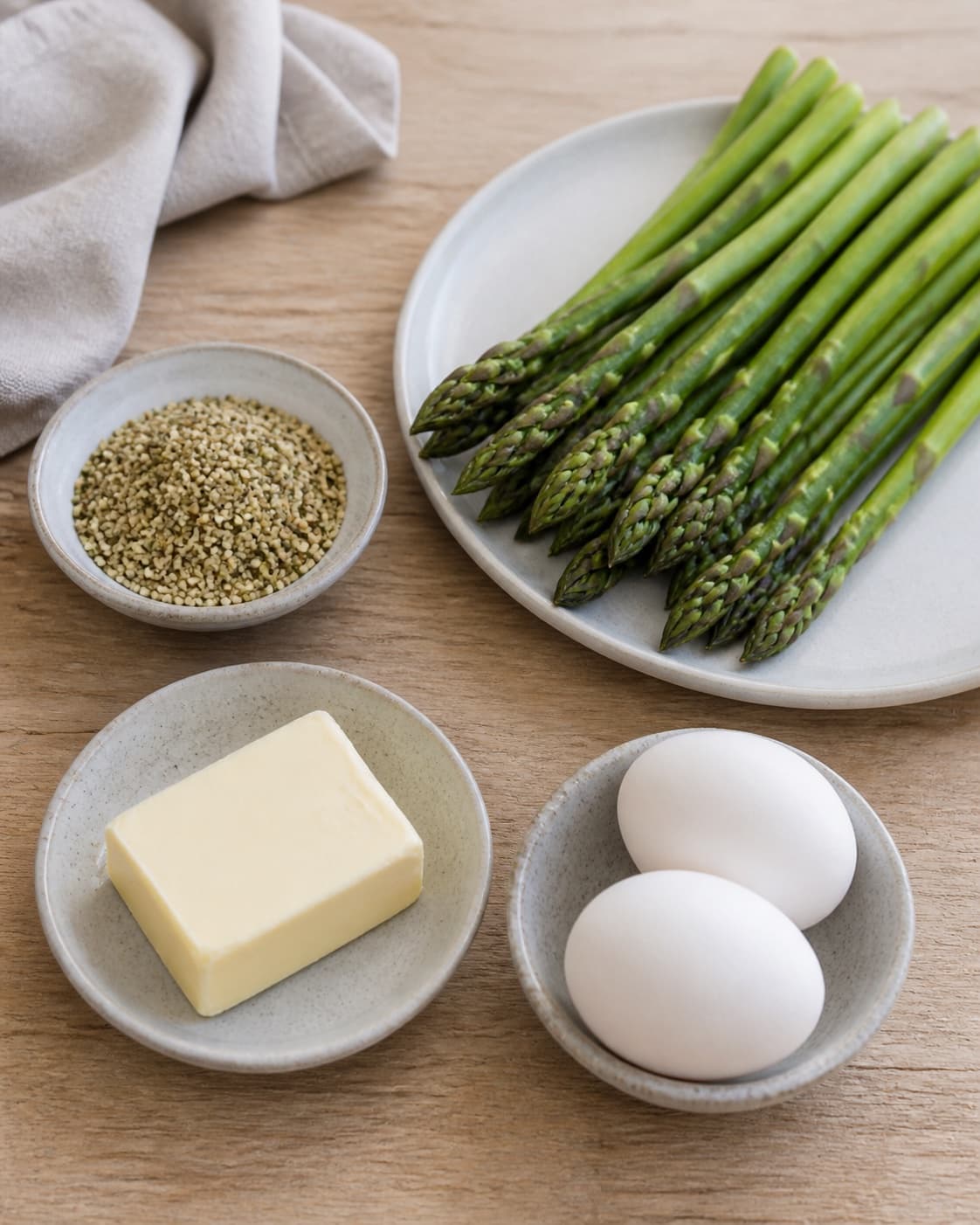 Prepared dry ingredients for grillede asparges med pocheret æg og ristede hampefrø with grønne asparges, æg, hampefrø, smør under tilberedningen af grillede asparges med pocheret æg og ristede hampefrø