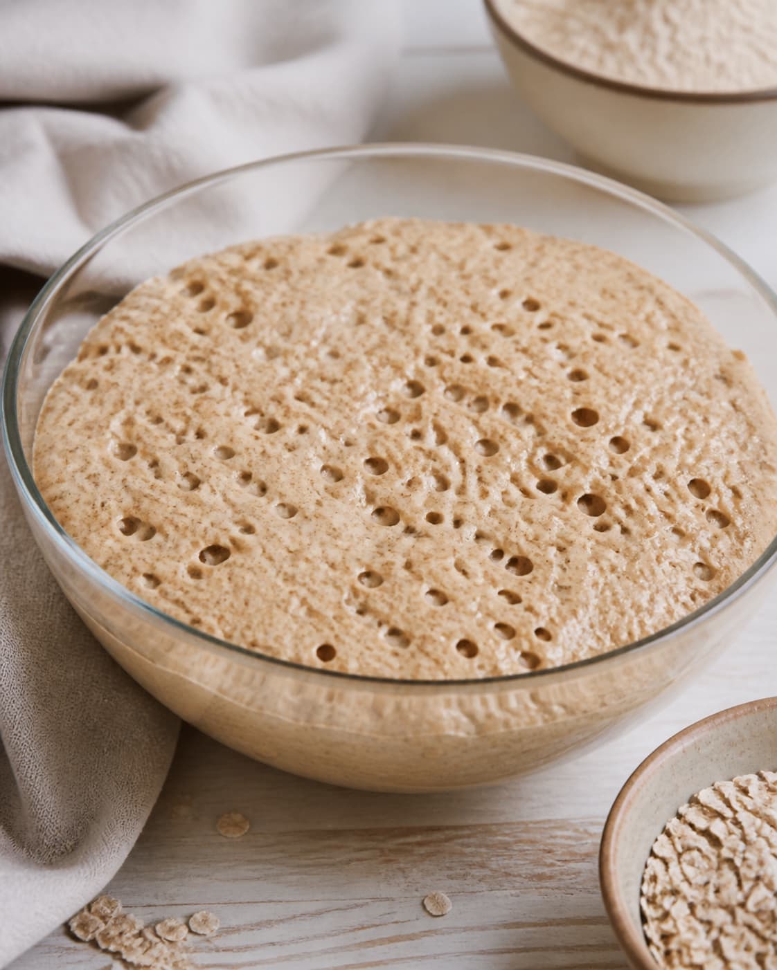 Proofed airy dough for koldhævede surdejsboller med rugmel og havre with visible fermentation bubbles under tilberedningen af koldhævede surdejsboller med rugmel og havre