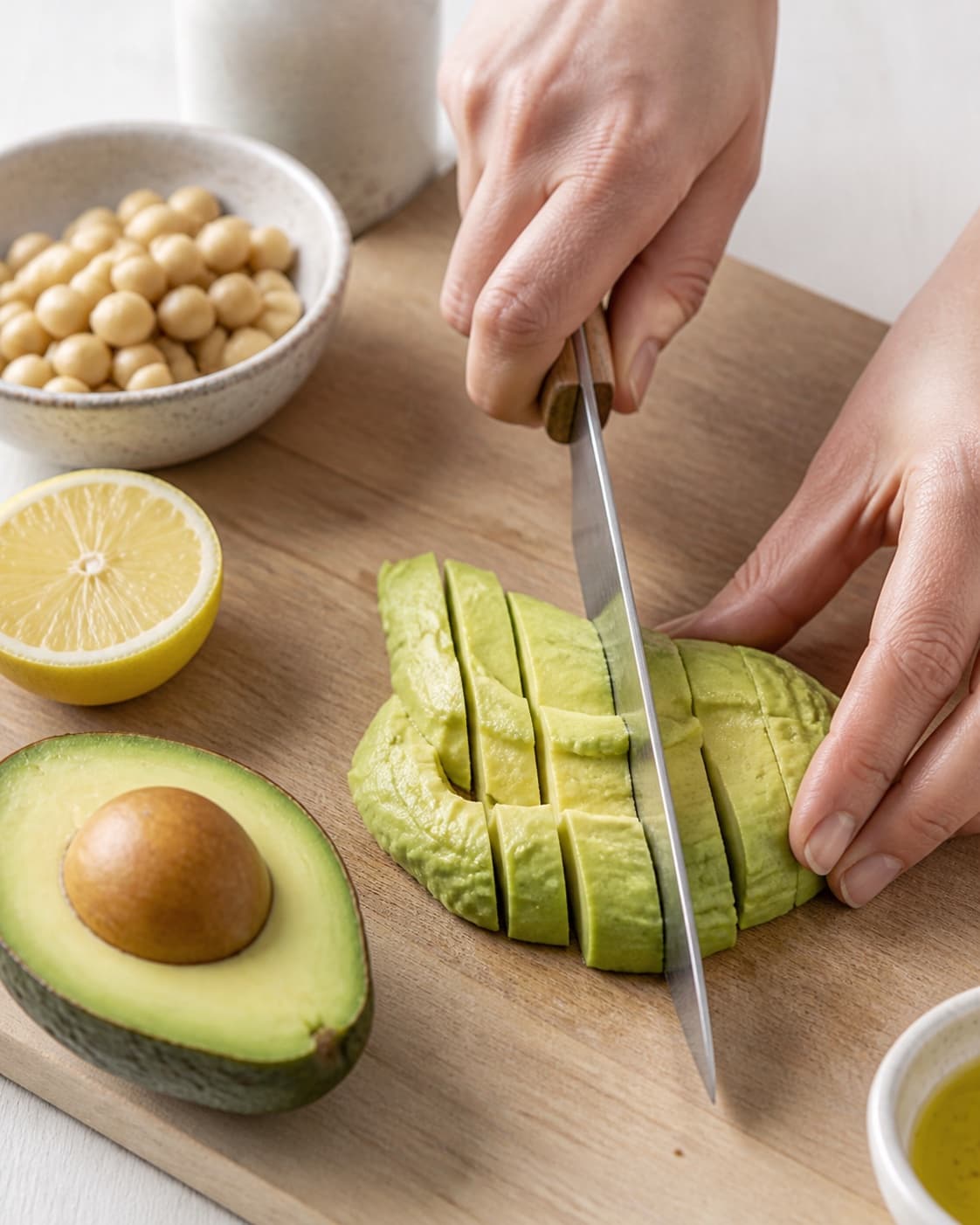 Ingredients for avocadohummus being cut into even pieces under tilberedningen af avocadohummus