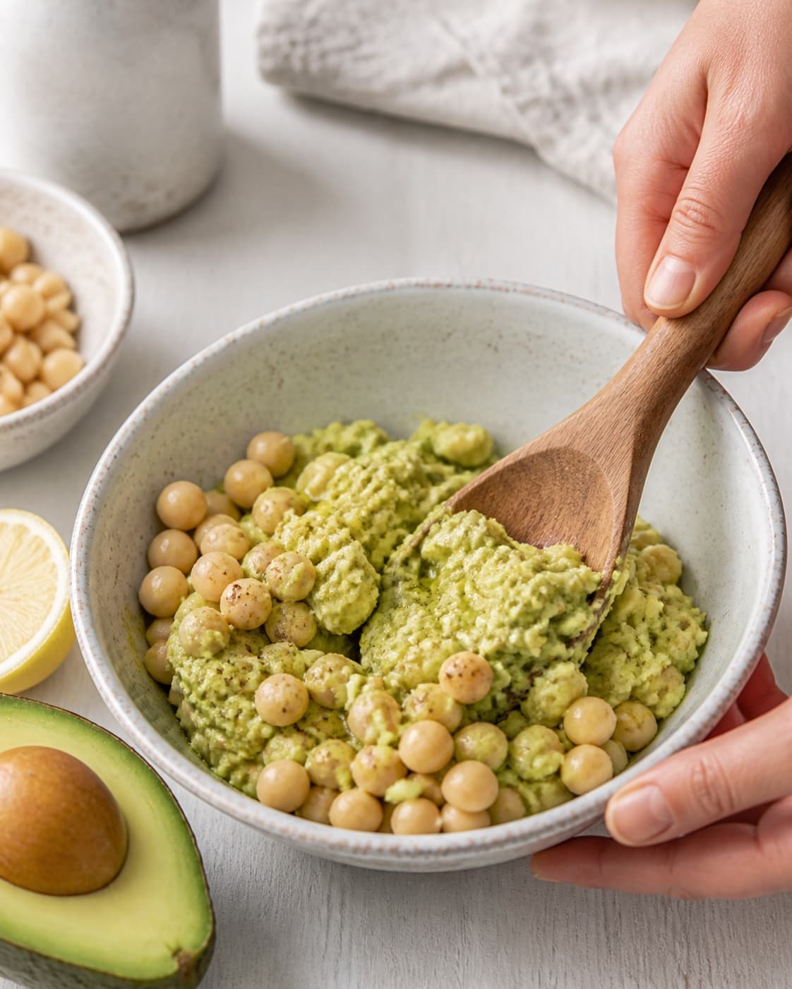 avocadohummus being gently combined without crushing the ingredients under tilberedningen af avocadohummus