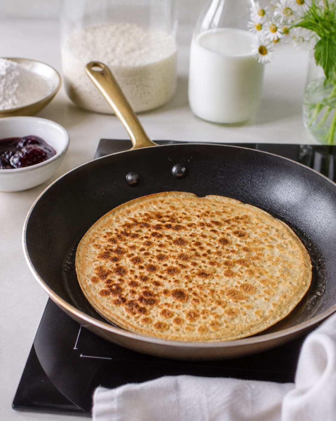 surdejspandekager frying to an even golden crust in a pan under tilberedningen af surdejspandekager