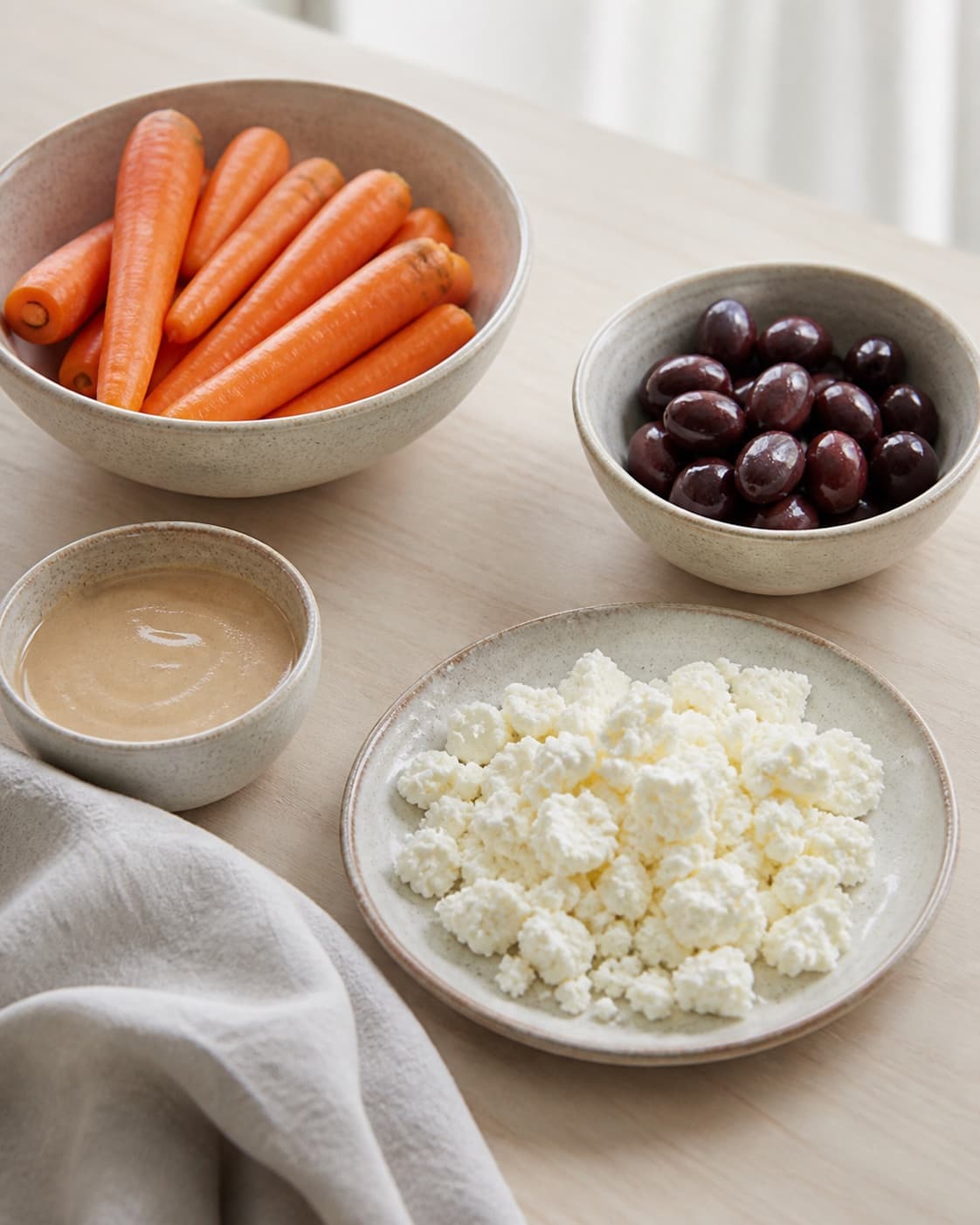 Prepared dry ingredients for grillede gulerødder med feta, oliven og tahin with gulerødder, kalamataoliven, tahin, feta under tilberedningen af grillede gulerødder med feta, oliven og tahin