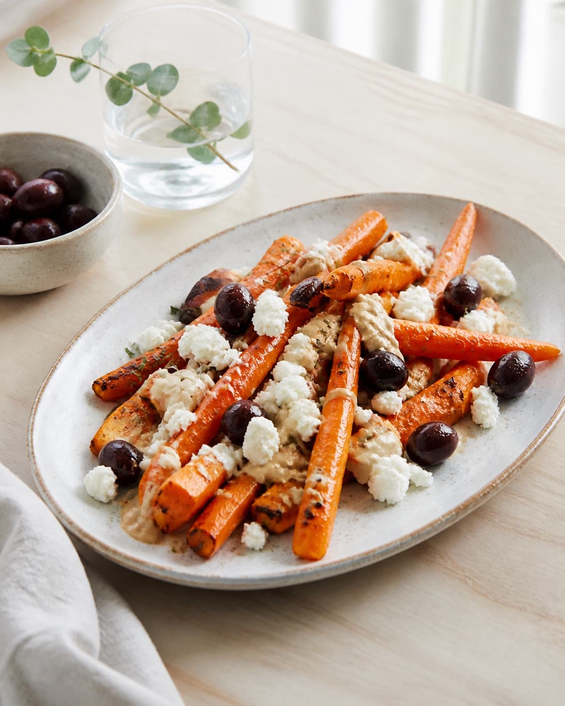 Finished grillede gulerødder med feta, oliven og tahin resting before the final garnish under tilberedningen af grillede gulerødder med feta, oliven og tahin