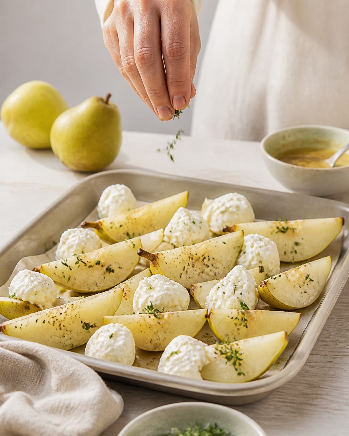 grillede pærer med gedeost og sennepsvinaigrette being evenly seasoned before roasting under tilberedningen af grillede pærer med gedeost og sennepsvinaigrette