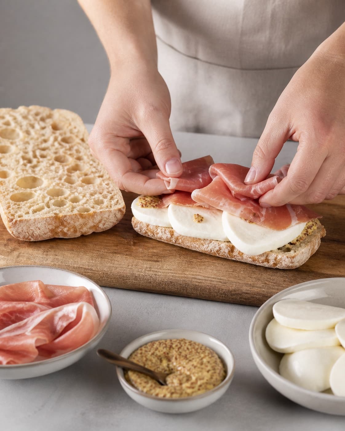 Prepared mixture for panini med serranoskinke, mozzarella og sennepsdressing with serranoskinke, ciabattabrød, mozzarella, dijonsennep under tilberedningen af panini med serranoskinke, mozzarella og sennepsdressing