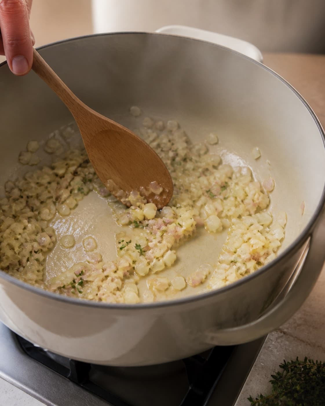 Aromatic base for græskarsuppe med kokosmælk gently cooking in a pot under tilberedningen af græskarsuppe med kokosmælk
