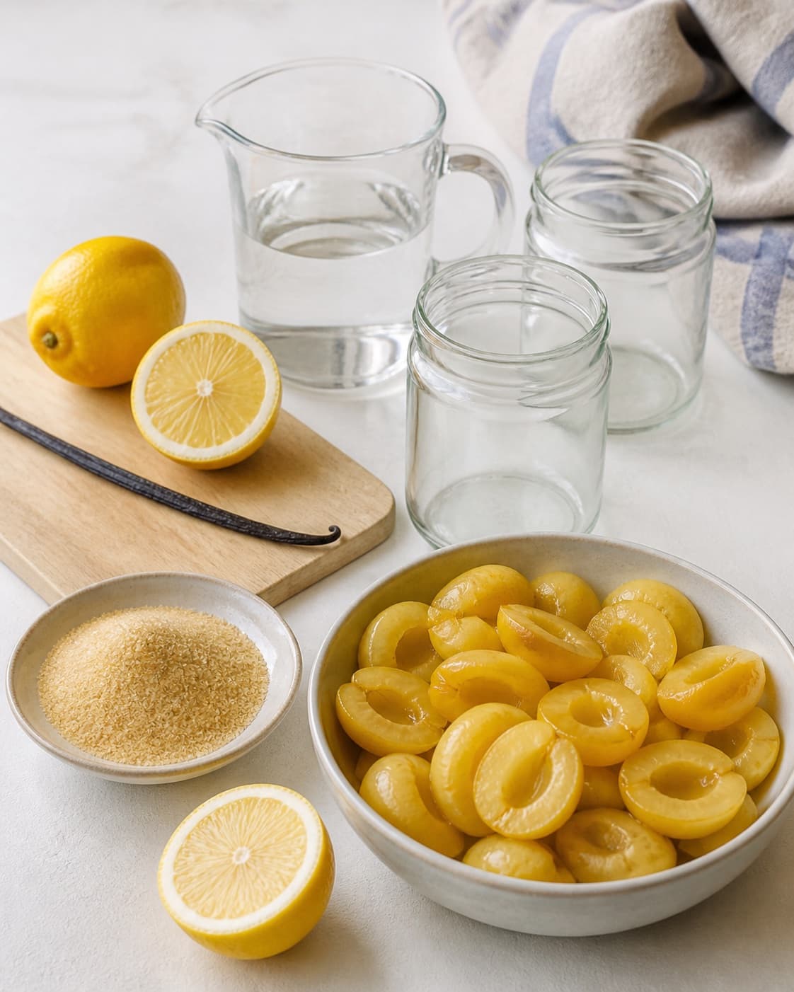 Clean measured ingredients and prepared jars for blommekompot med vanilje with modne blommer, rørsukker, vand, økologisk citron under tilberedningen af blommekompot med vanilje