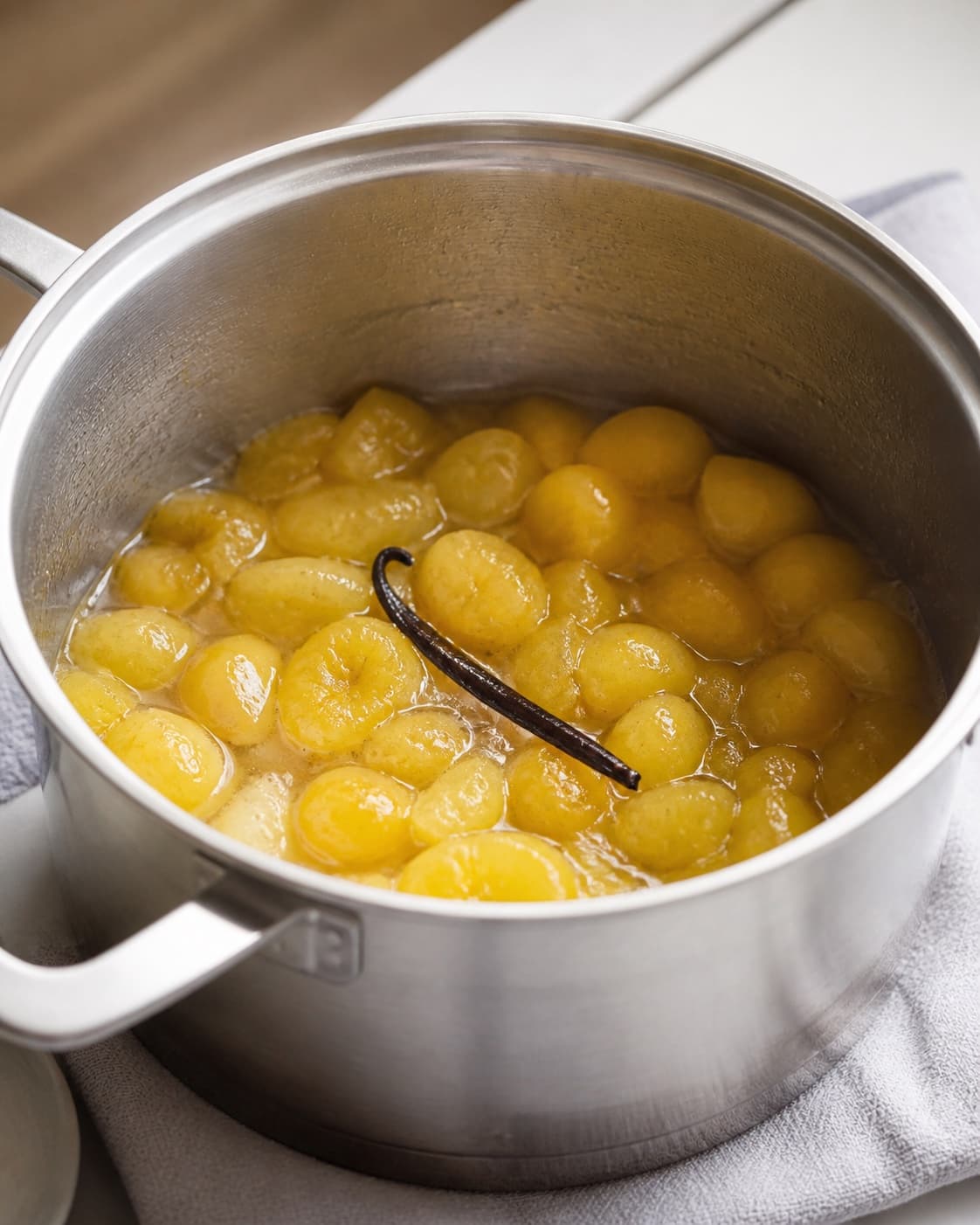 Ingredients for blommekompot med vanilje gently releasing juice in a pot under tilberedningen af blommekompot med vanilje