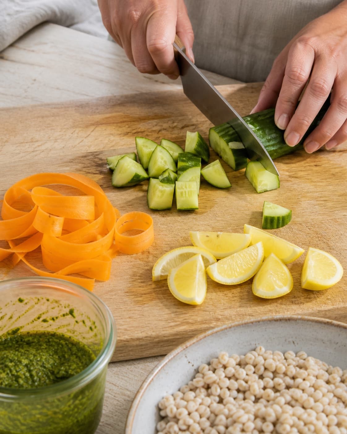 Ingredients for perlebygsalat med urteolie og crudité being cut into even pieces under tilberedningen af perlebygsalat med urteolie og crudité