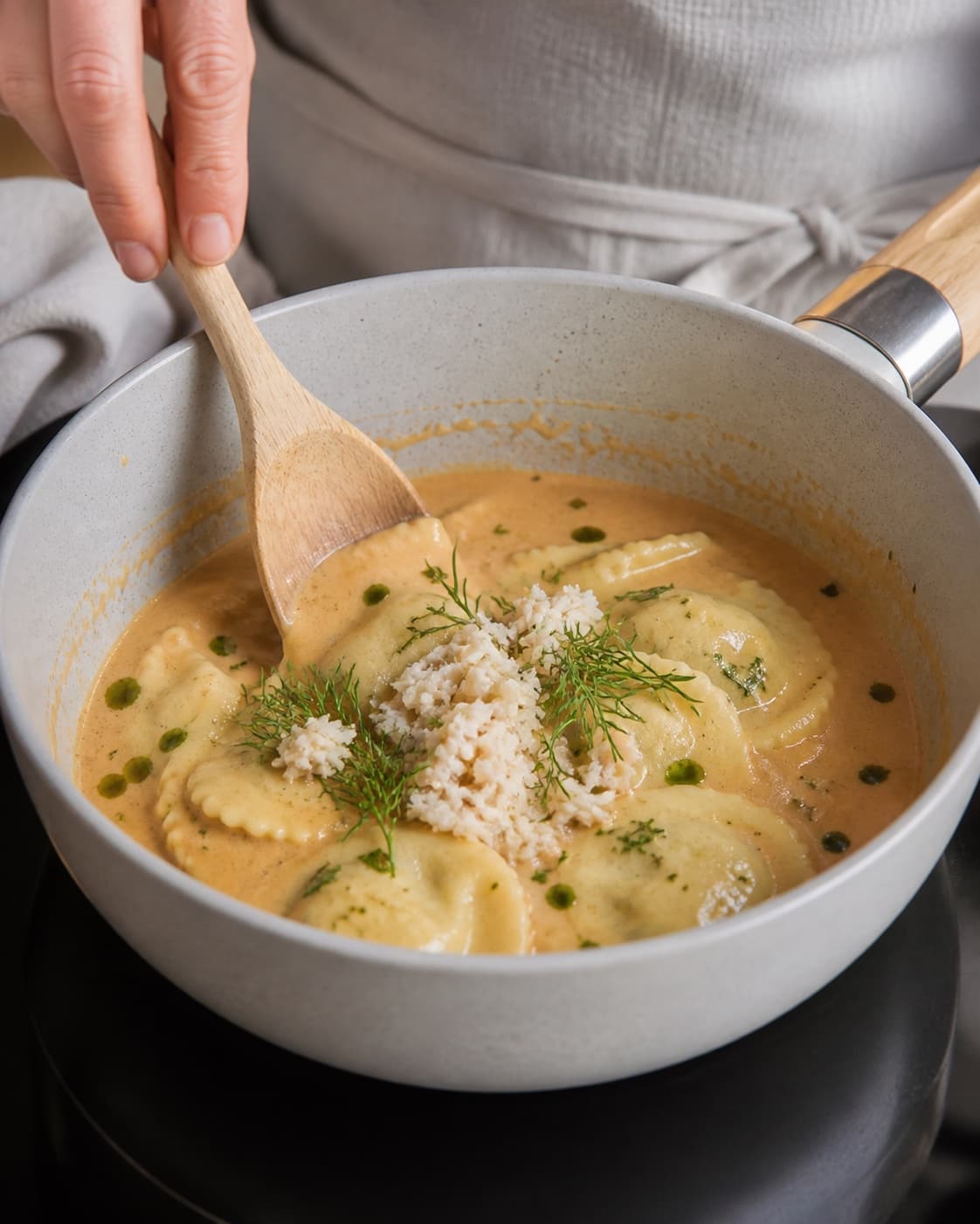 Creamy texture of strandkrabbebisque med ravioli being adjusted off the heat under tilberedningen af strandkrabbebisque med ravioli