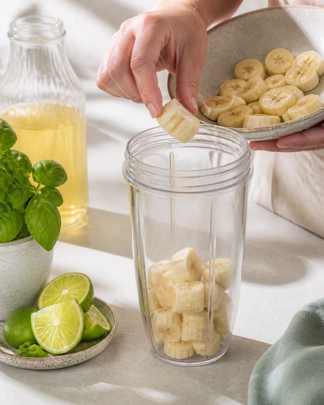 Fresh flavour ingredients for smoothie med basilikum og lime prepared with modne bananer, æblejuice, frisk basilikum, økologisk lime under tilberedningen af smoothie med basilikum og lime