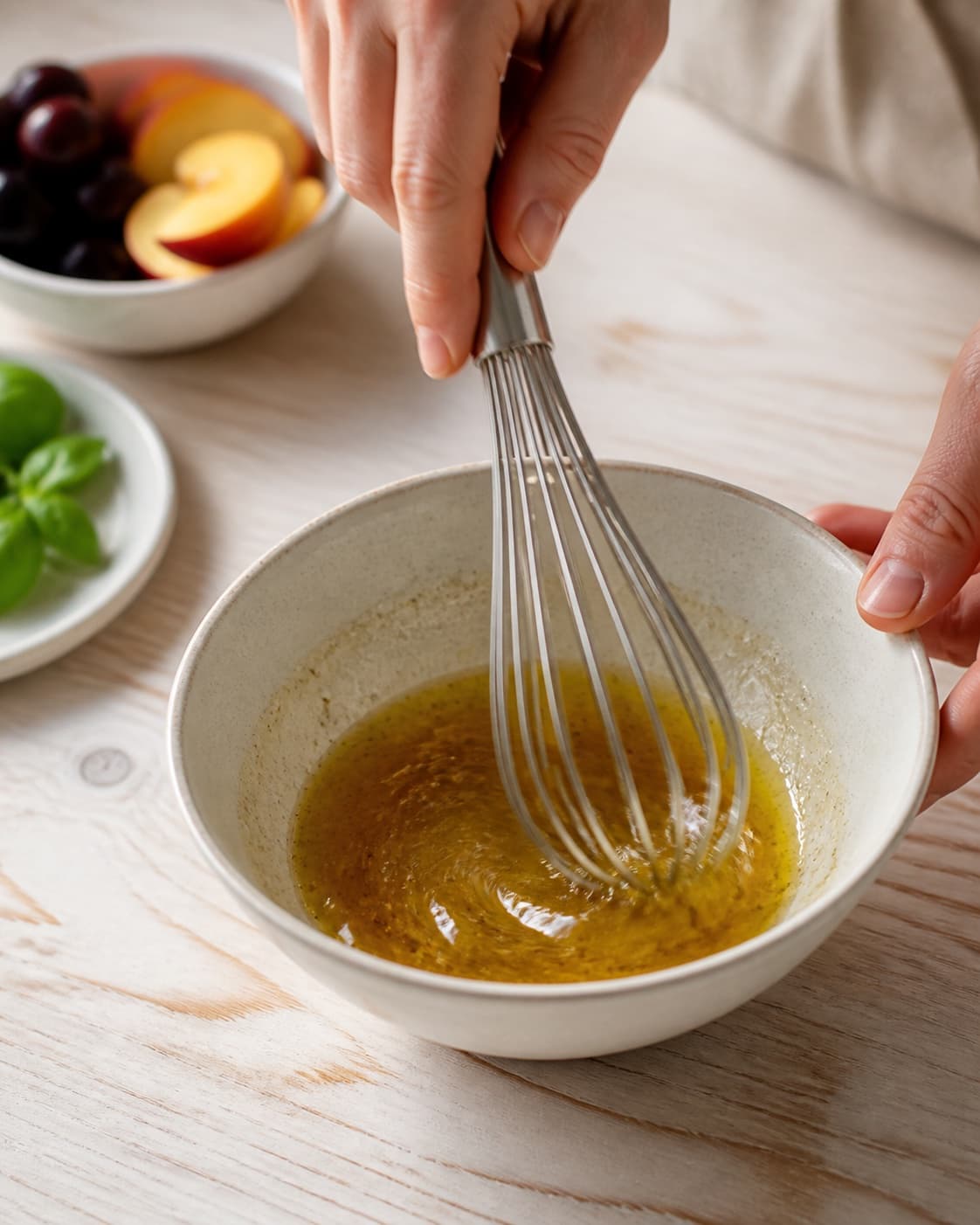 Dressing for salat med mozzarella, fersken og serrano being whisked until glossy under tilberedningen af salat med mozzarella, fersken og serrano