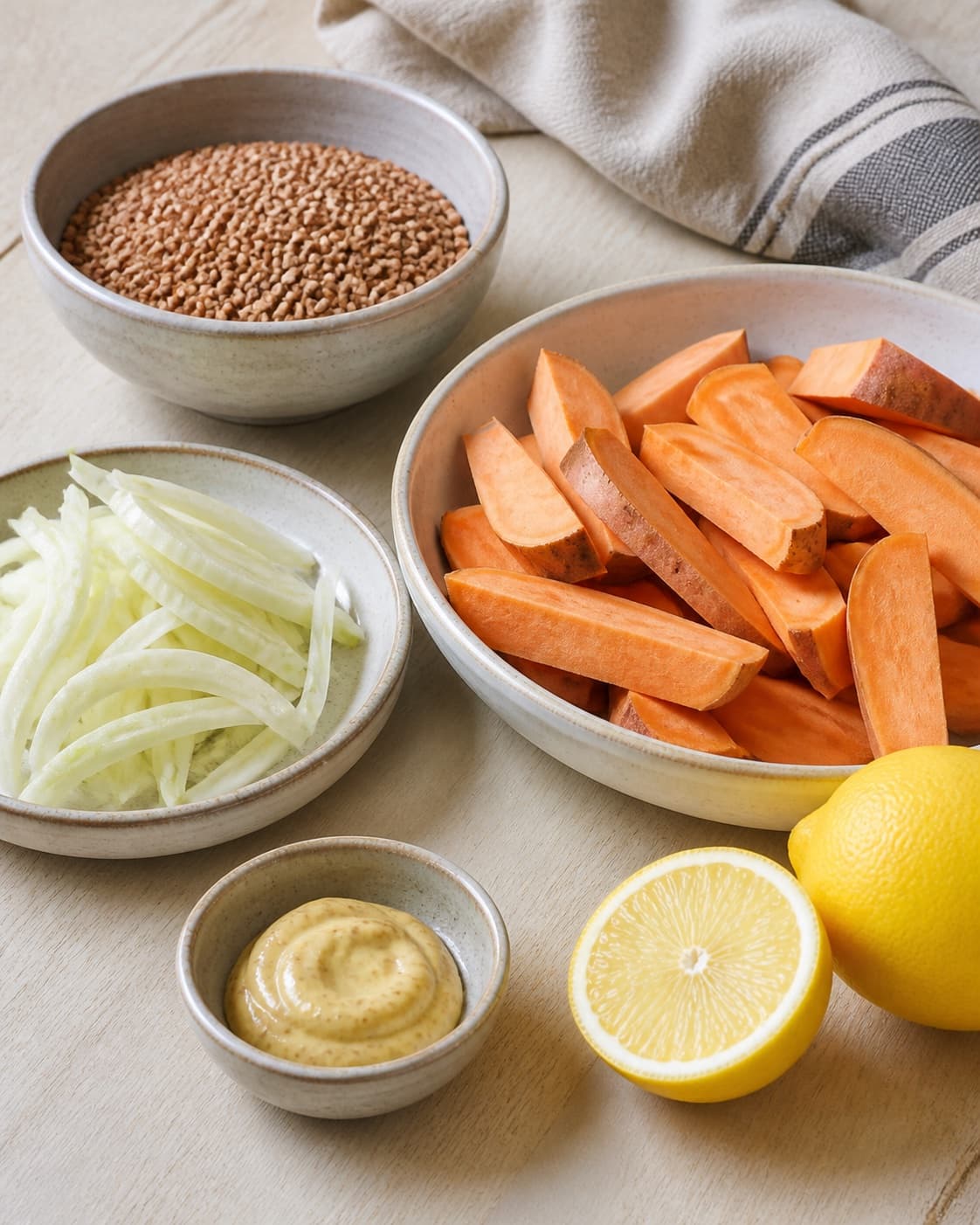 Clean prepared ingredients for sød kartoffel salat med boghvede og sennepsdressing with boghvedekerner, dijonsennep, søde kartofler, økologisk citron under tilberedningen af sød kartoffel salat med boghvede og sennepsdressing