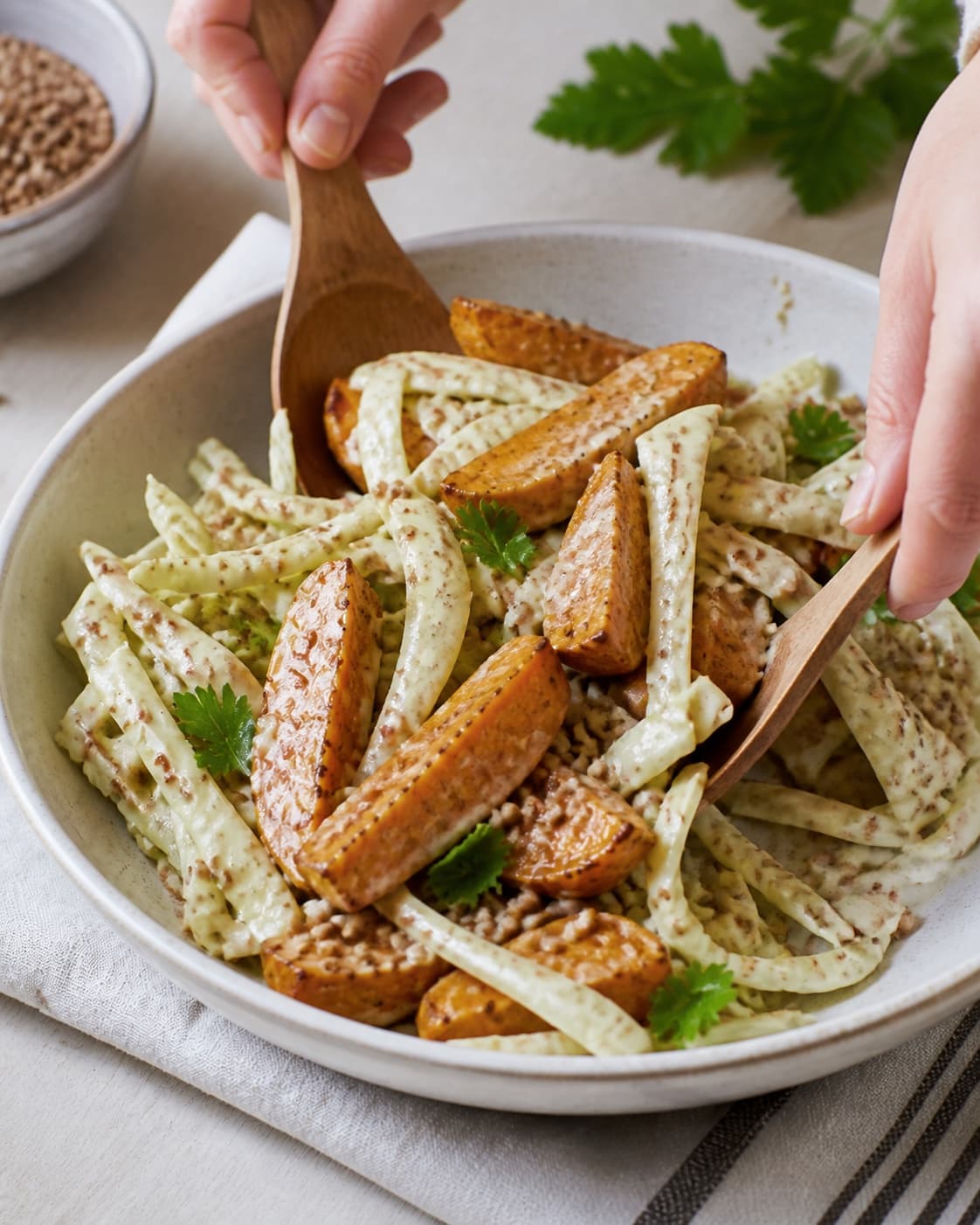 sød kartoffel salat med boghvede og sennepsdressing being gently combined without crushing the ingredients under tilberedningen af sød kartoffel salat med boghvede og sennepsdressing