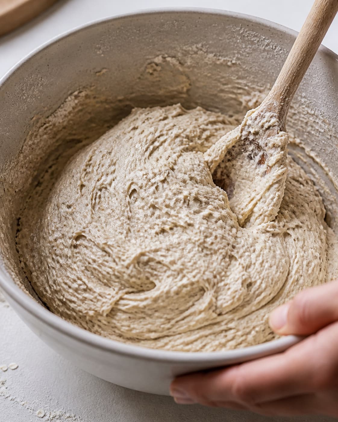 Close view of the moist dough for koldhævede boller being mixed in a bowl with hvedemel, lunkent vand, gær, fint salt under tilberedningen af koldhævede boller