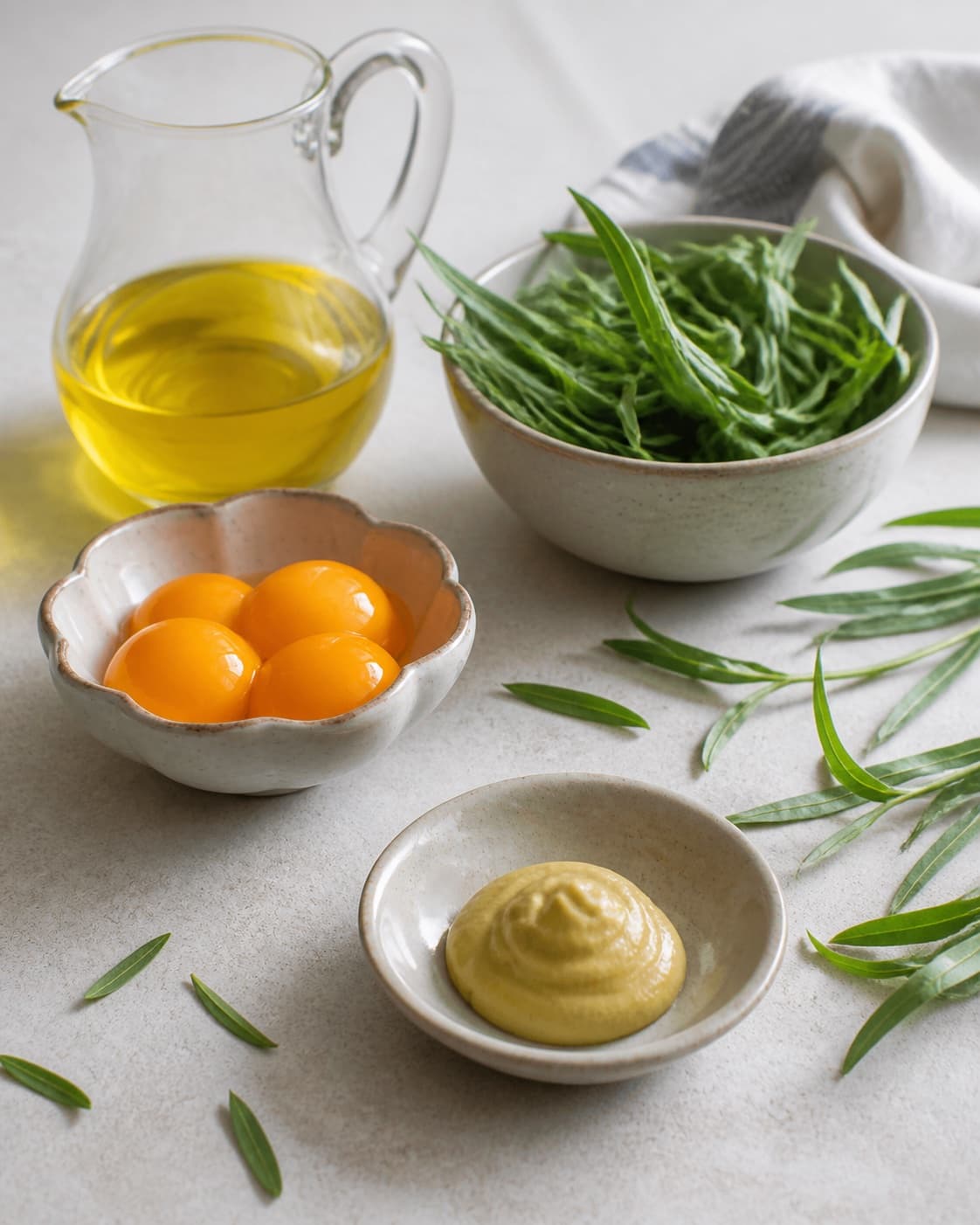 Clean prepared ingredients for hjemmelavet estragonmayo with pasteuriserede æggeblommer, rapsolie, frisk estragon, dijonsennep under tilberedningen af hjemmelavet estragonmayo