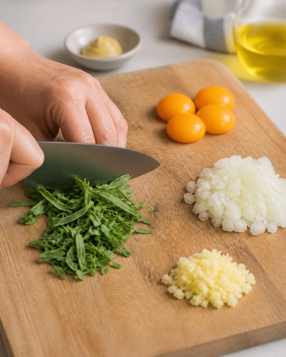 Ingredients for hjemmelavet estragonmayo being cut into even pieces under tilberedningen af hjemmelavet estragonmayo