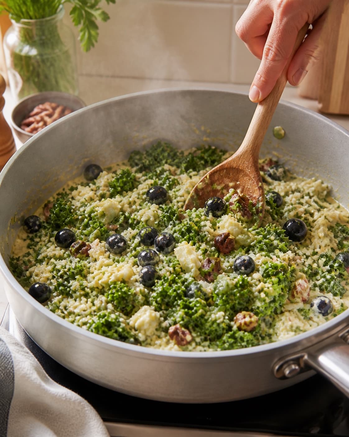 cremet rissalat med grønkål og karrydressing gently simmering with visible ingredients under tilberedningen af cremet rissalat med grønkål og karrydressing