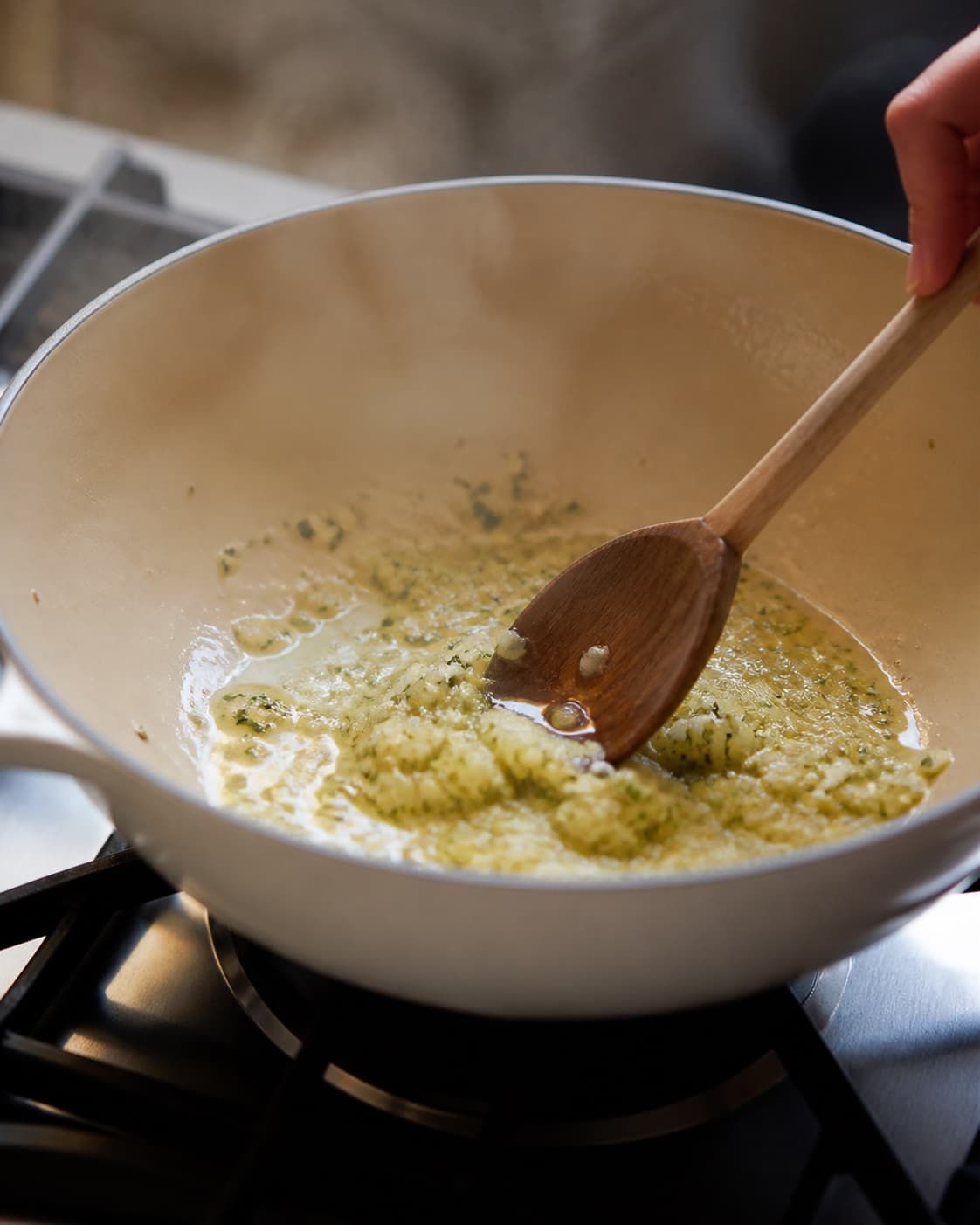 Aromatic base for galette med spinat, gedeost og pesto gently cooking in a pot under tilberedningen af galette med spinat, gedeost og pesto