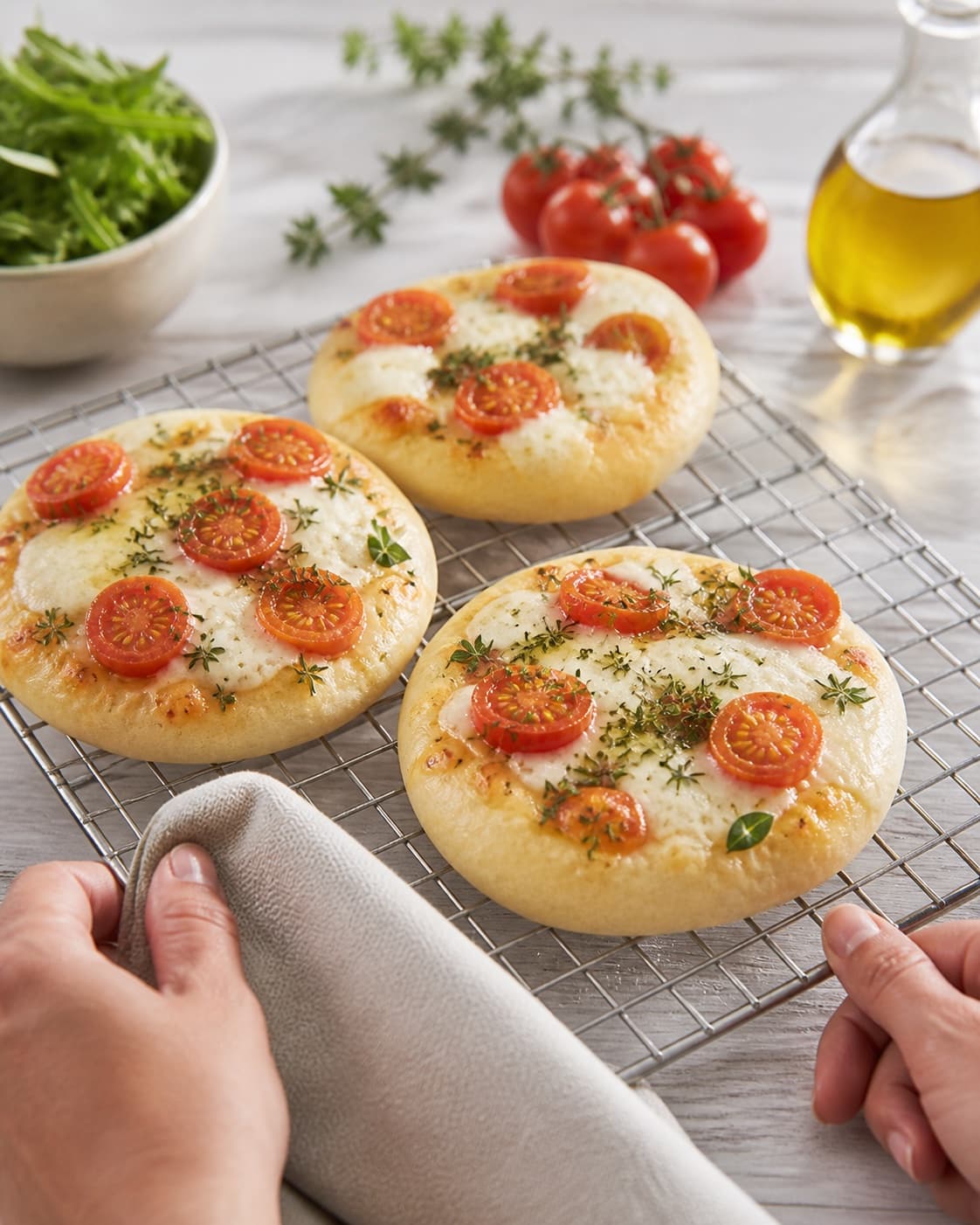Golden baked mini foccaciabrød med mozzarella og tomat cooling on a wire rack under tilberedningen af mini foccaciabrød med mozzarella og tomat