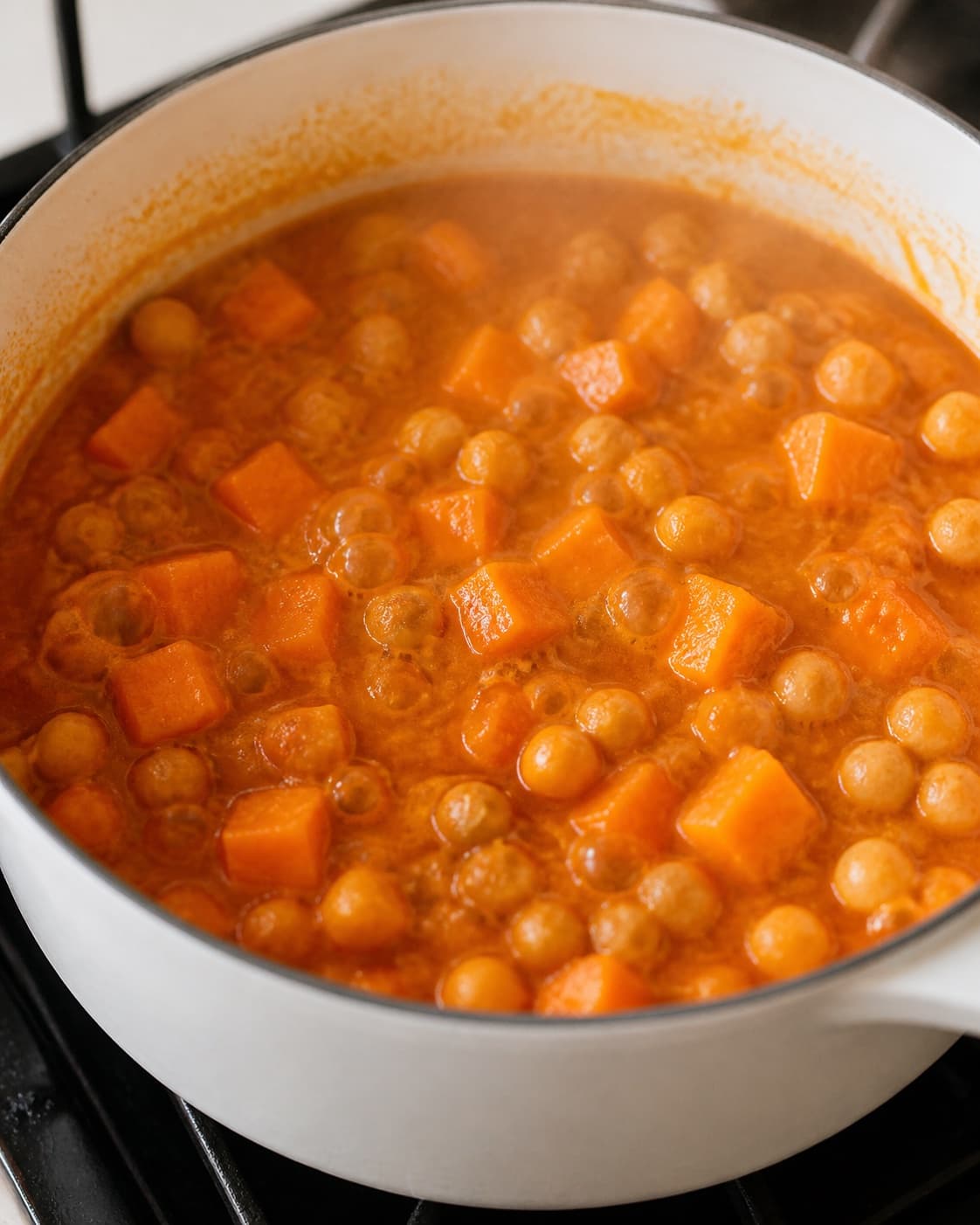 kikærtegryde med græskar gently simmering with visible ingredients under tilberedningen af kikærtegryde med græskar