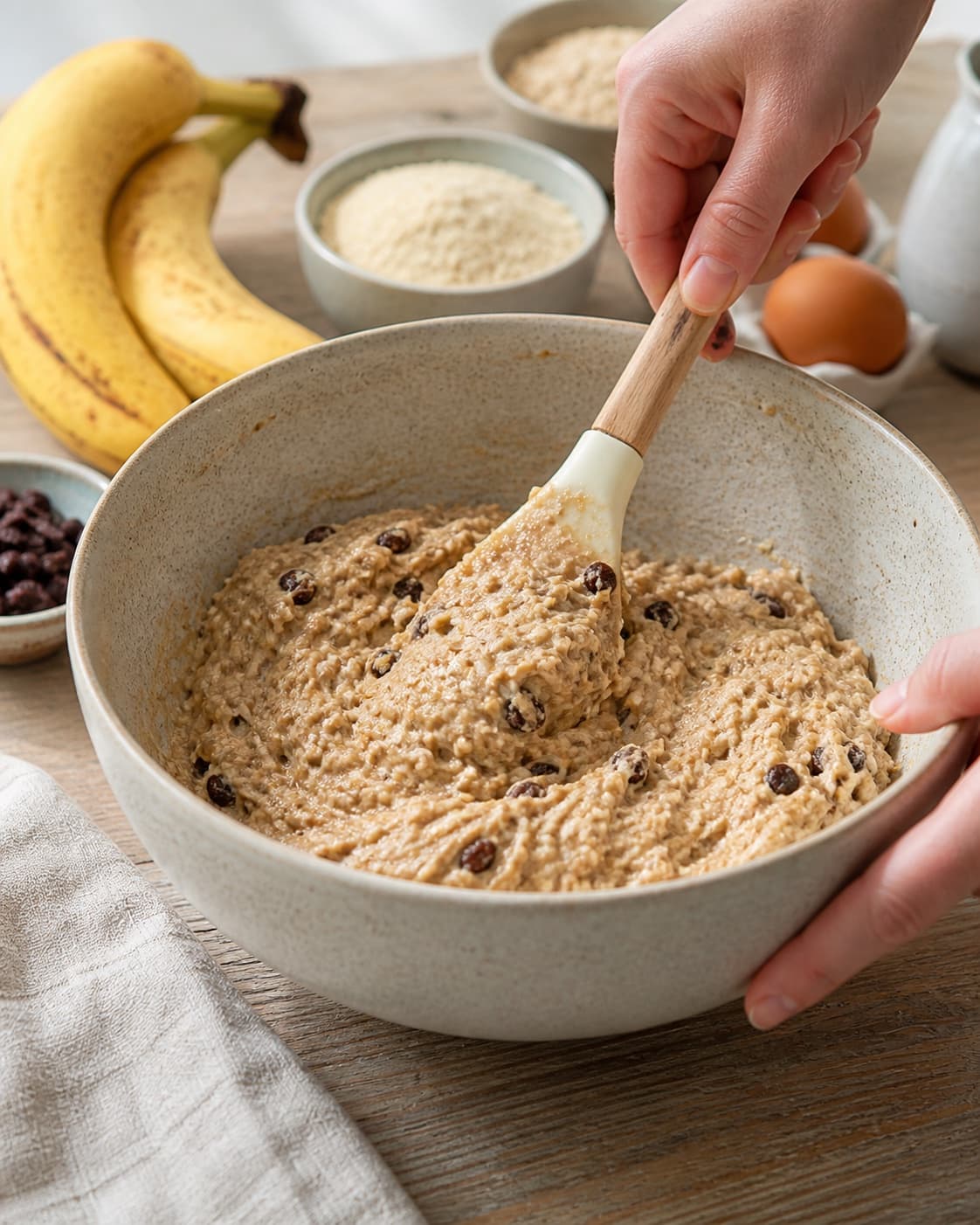 The batter or dough for sundt bananbrød uden mel og raffineret sukker being gently combined under tilberedningen af sundt bananbrød uden mel og raffineret sukker