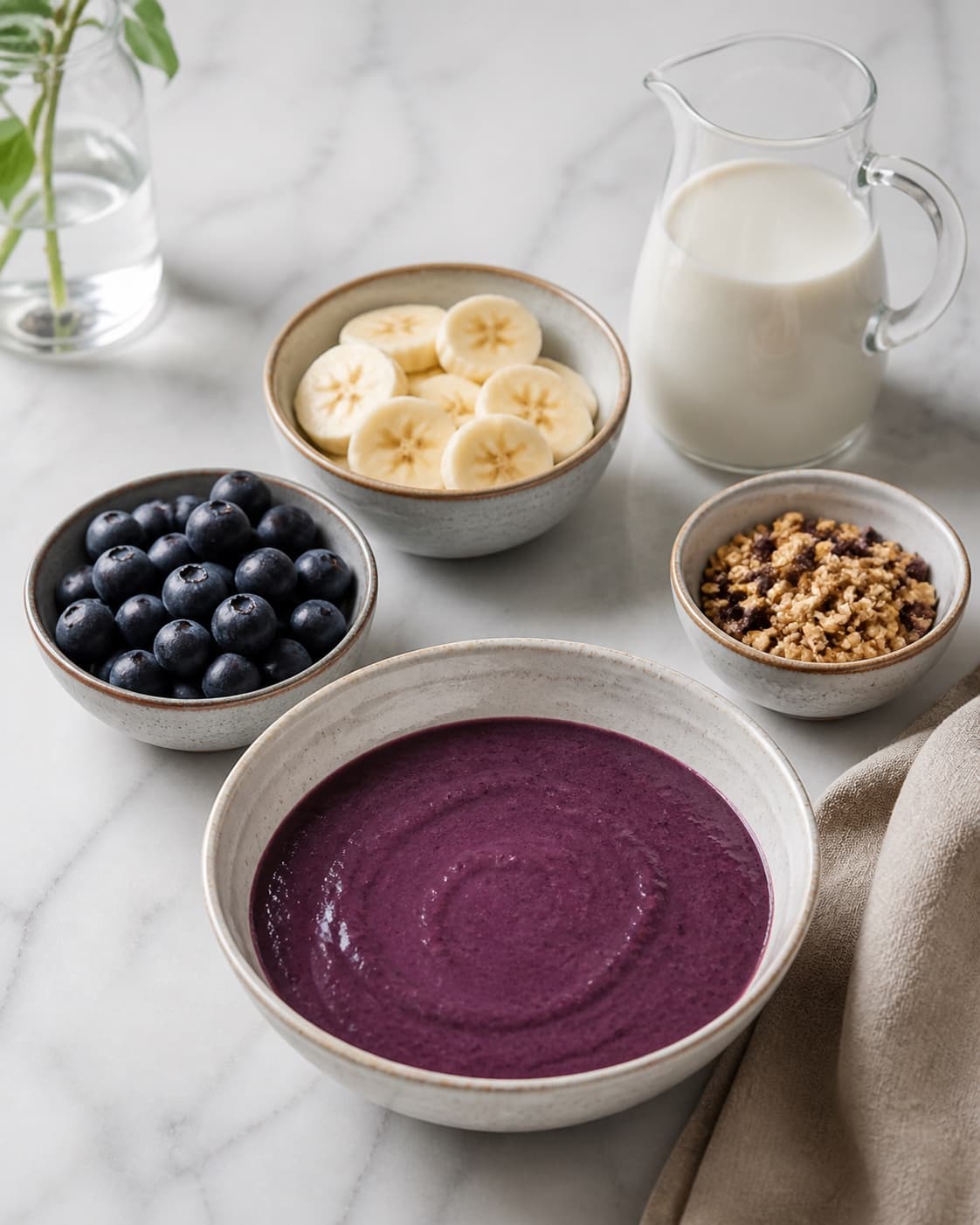 Clean prepared ingredients for acai bowl with açaípuré, modne bananer, blåbær, havredrik under tilberedningen af acai bowl