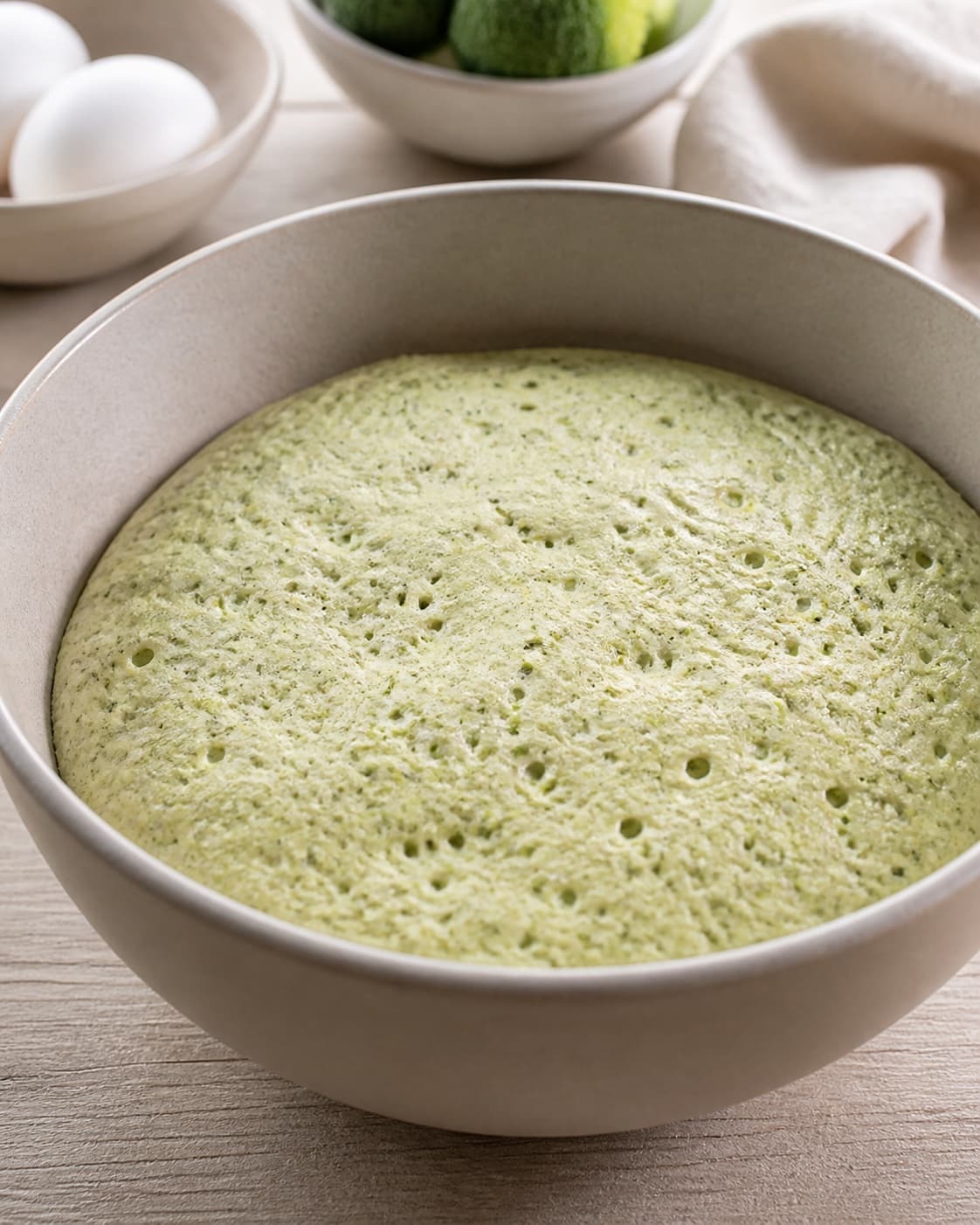 Proofed airy dough for broccoliboller uden mel with visible fermentation bubbles under tilberedningen af broccoliboller uden mel