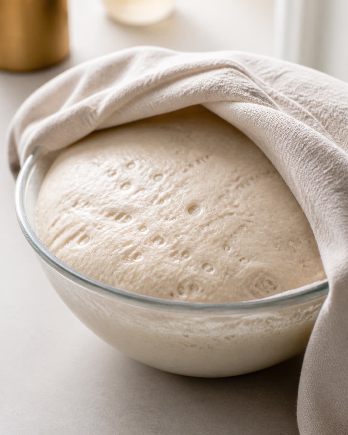 Proofed airy dough for pitabrød med falafel og hvidløgsdressing with visible fermentation bubbles under tilberedningen af pitabrød med falafel og hvidløgsdressing