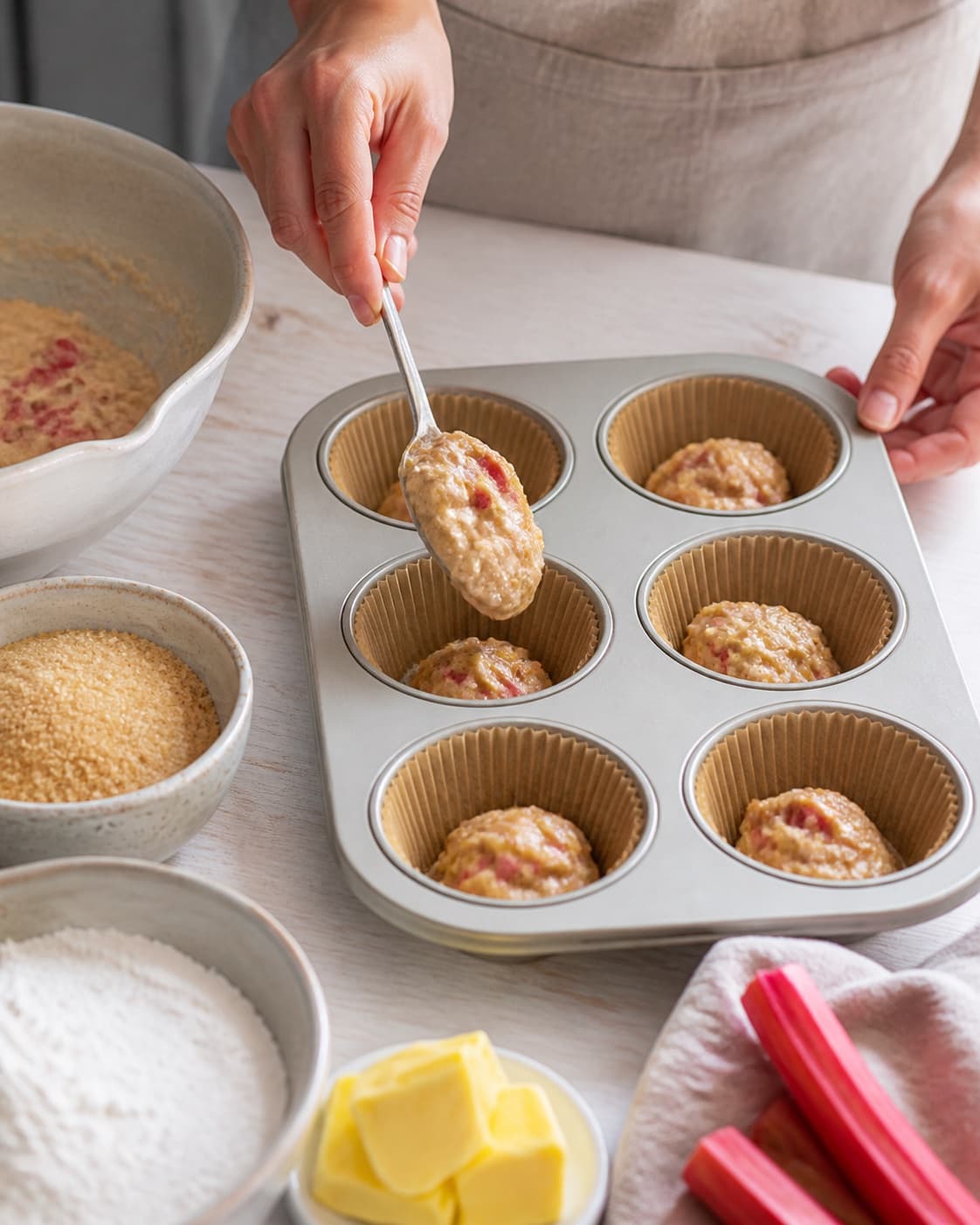 sunde rabarbermuffins being portioned evenly before baking under tilberedningen af sunde rabarbermuffins