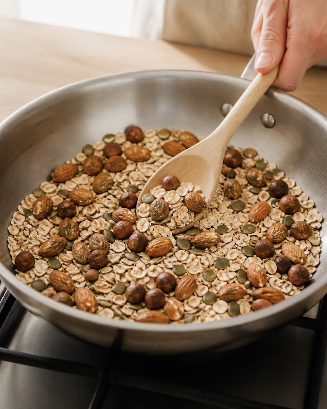 Oats almonds hazelnuts and pumpkin seeds being lightly toasted for muesli bars under tilberedningen af myslibar med chokolade og nødder