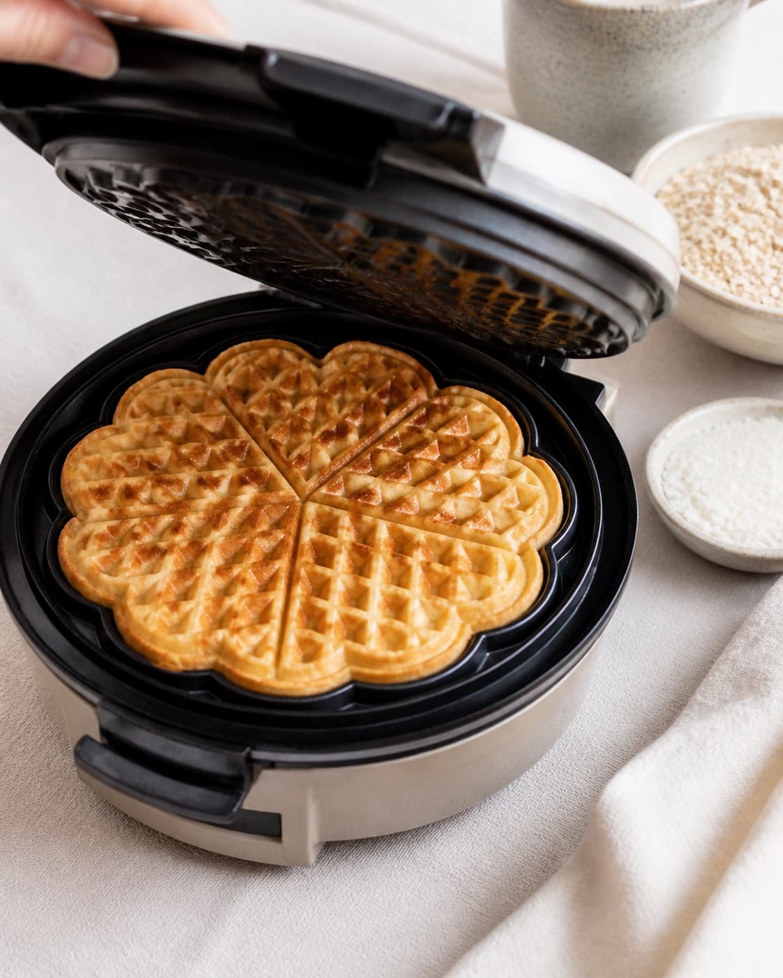Coconut oat waffles baking until the patterned surface is golden and crisp under tilberedningen af kokosvafler med toppings