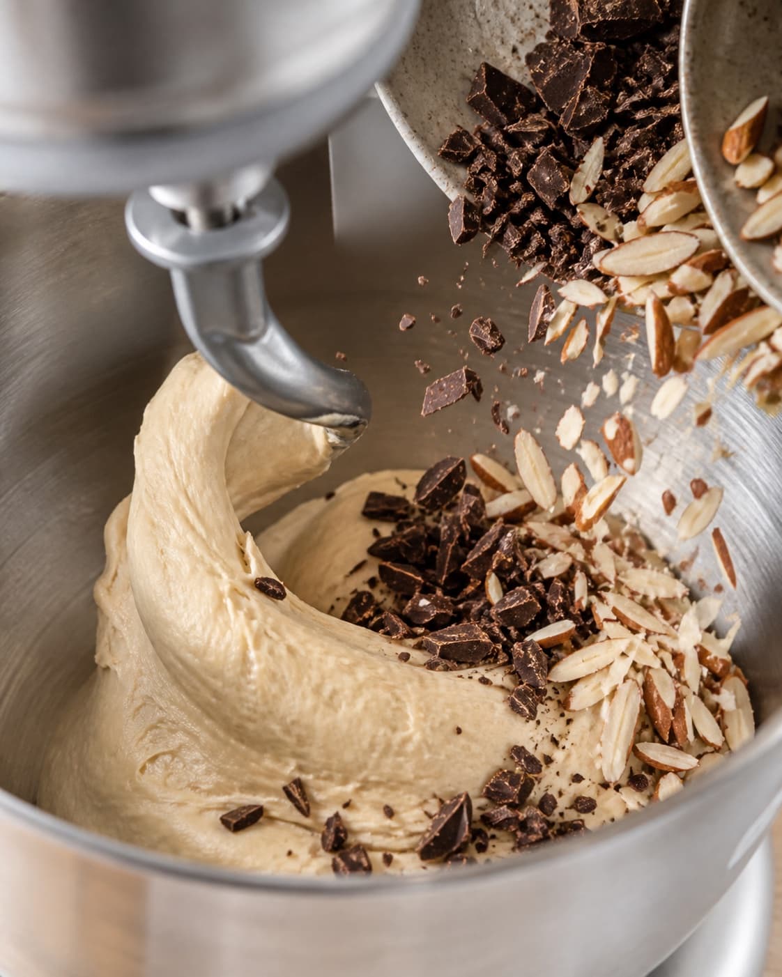 Elastic enriched dough receiving chopped almonds and dark chocolate at low speed under tilberedningen af mandelboller med chokolade