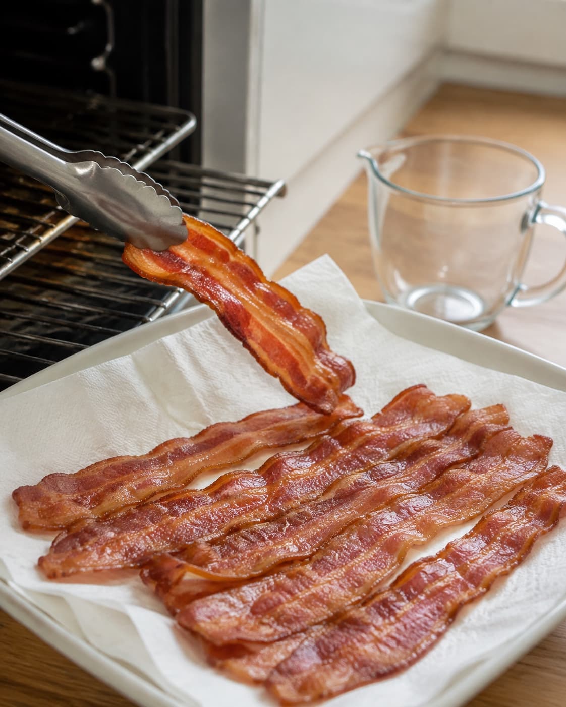 Gylden bacon flyttes fra ovnrist til køkkenpapir for fem minutters hvile